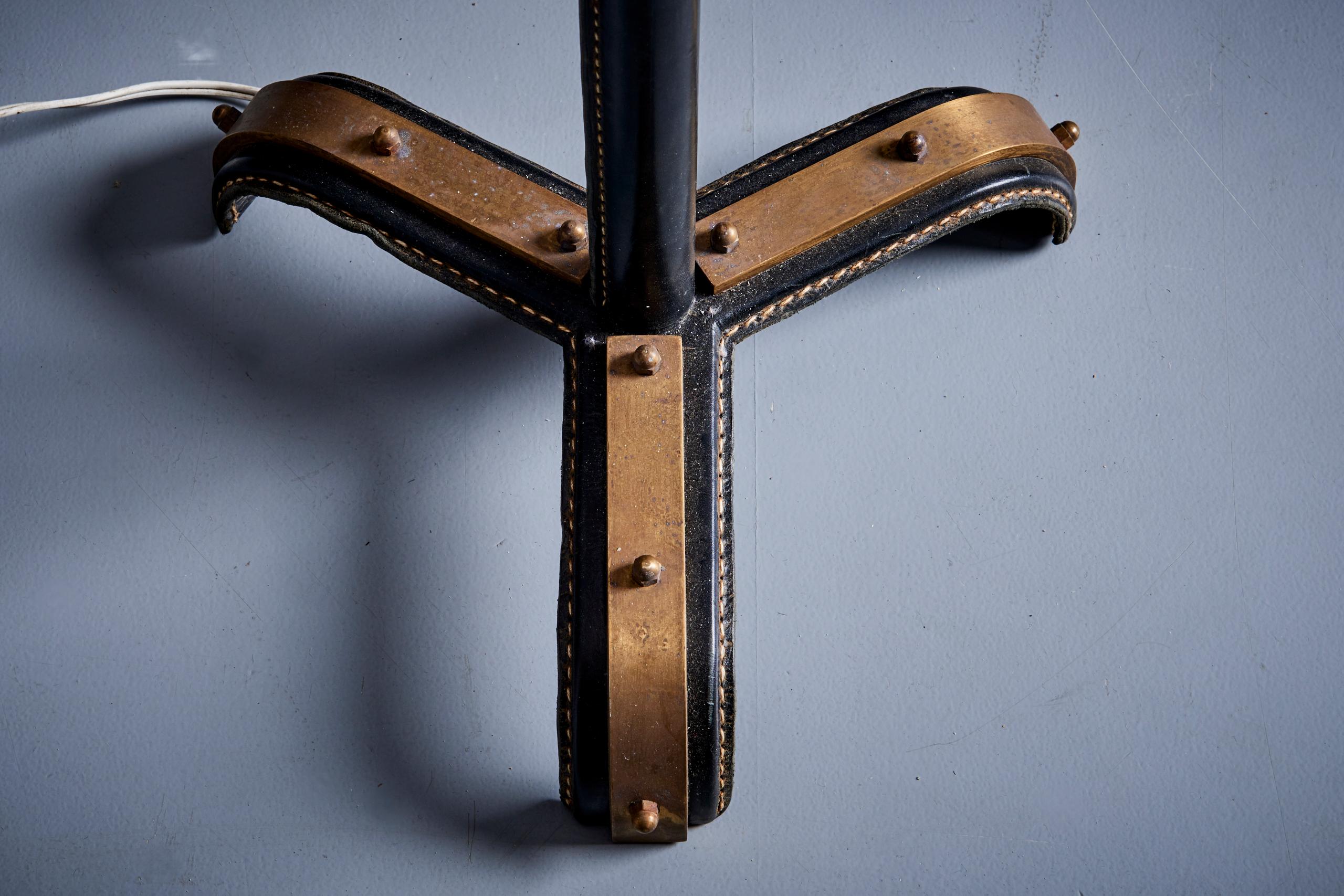 Lampadaire en métal de Jacques Adnet avec de beaux détails en cuir, France - années 1950. Les mesures indiquées s'appliquent à la lampe sans l'abat-jour.

Remarque : la lampe doit être installée par un professionnel conformément aux exigences