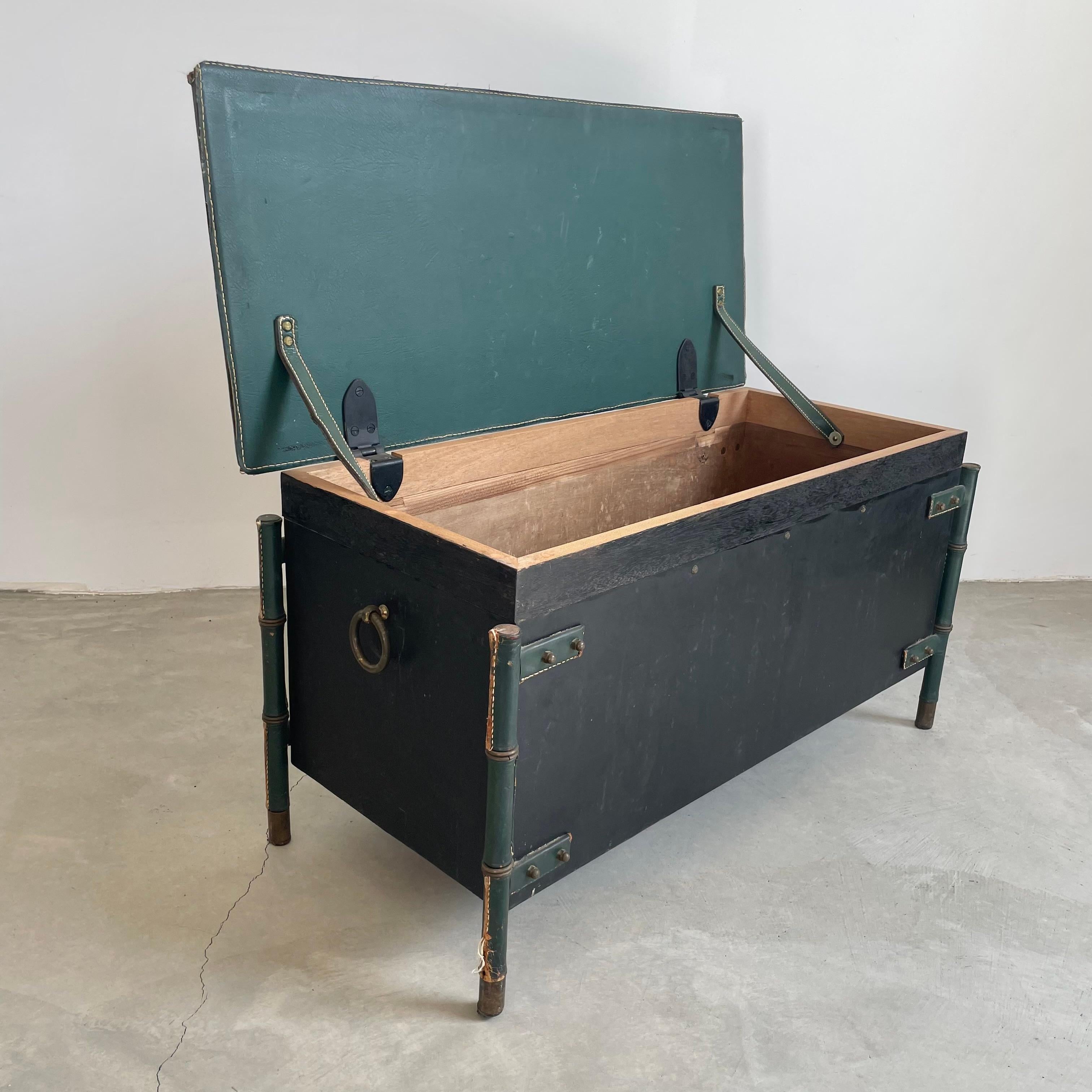 Stunning and rare Jacques Adnet storage bench in green leather and solid oak. Heavy and well built, strong enough to hold multiple people sitting on it and very roomy inside to place items in. Perfectly proportioned French modernist design. Brass
