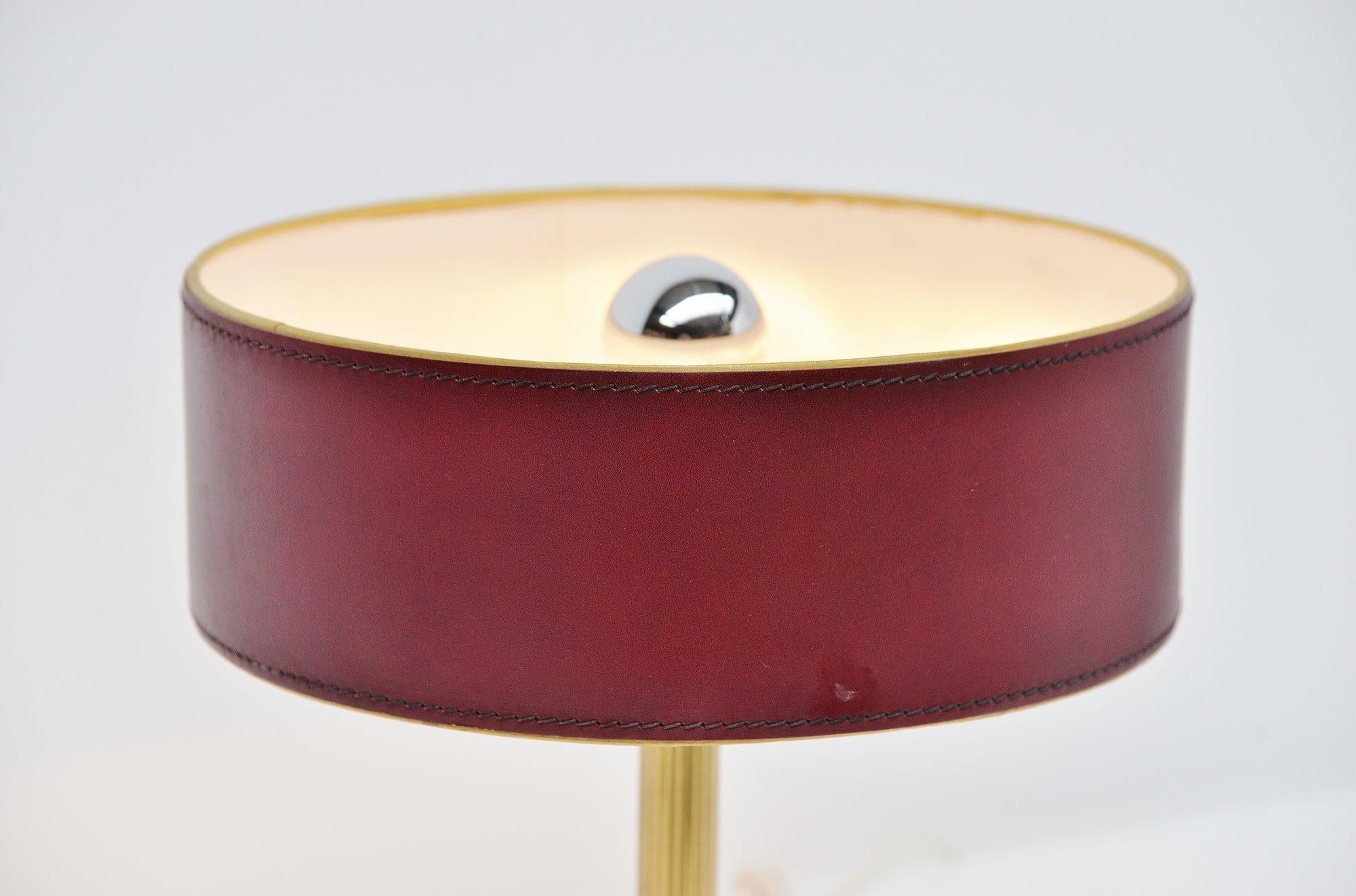 Very nice and highly decorative table lamp designed by Jacques Adnet, France, 1960. This leather clad table lamp has a square shade and a brass stem, the shade is made of leather too. High quality stitching on this lamp. The lamp is in very nice