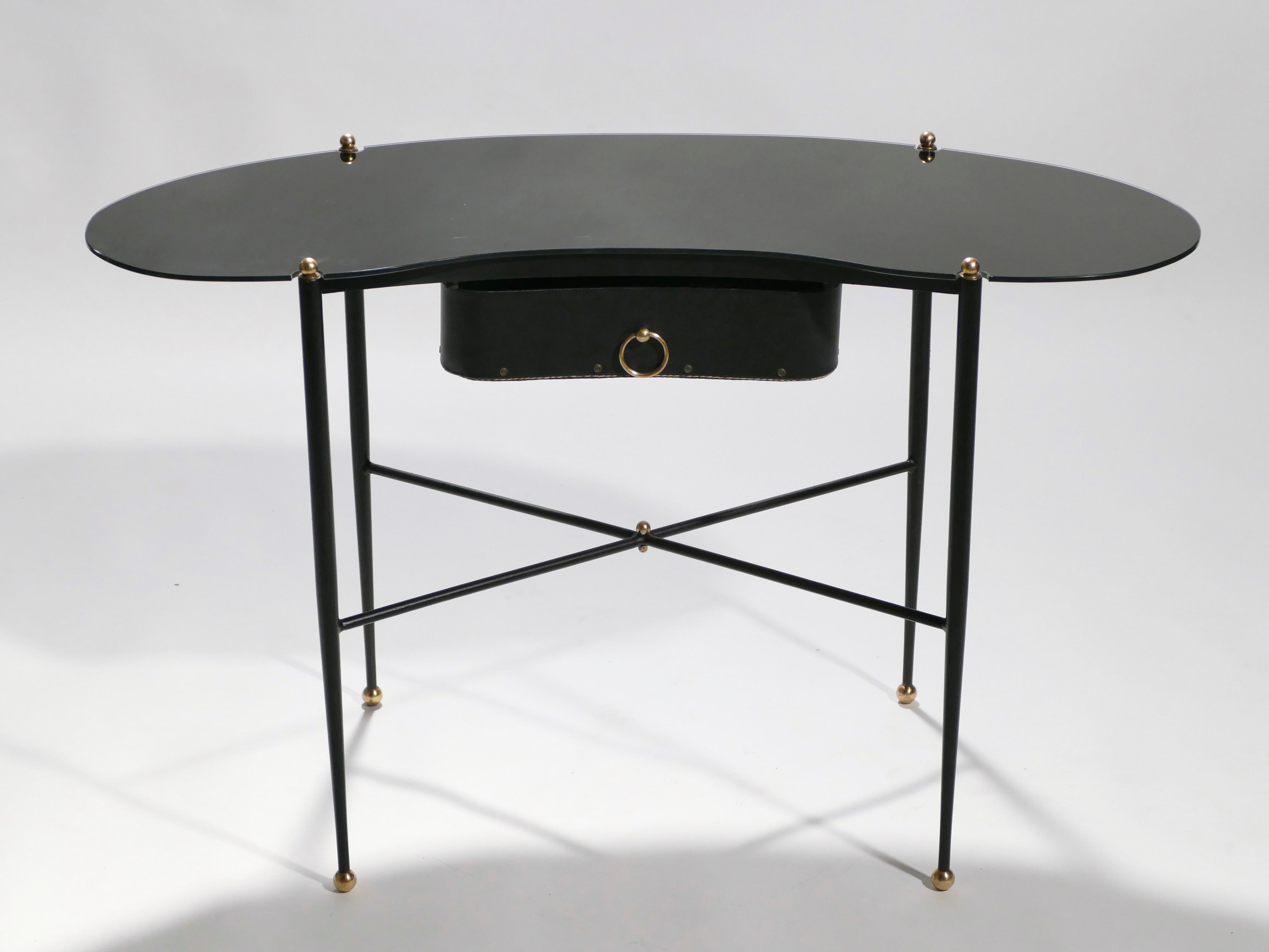 This vanity desk and stool set are rendered in monochromatic black, created by black metal, black opaline, and black piqué sellier (saddle stich) leather. The sleek look is interrupted only by small, charming brass accents—an Apt choice to both