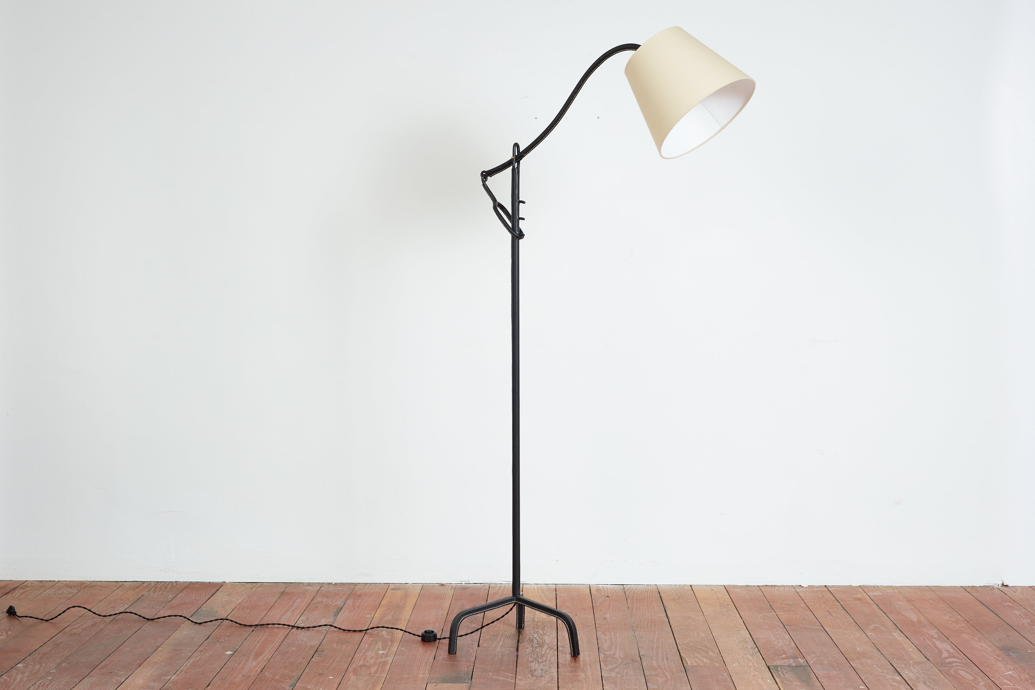 Jacques Adnet Leather Articulating  Floor Lamp 
Iron completely wrapped with black leather and signature contrast stitching 
Leather tripod base, stem and arm 
New silk lamp shade. 

France, 1940s 



