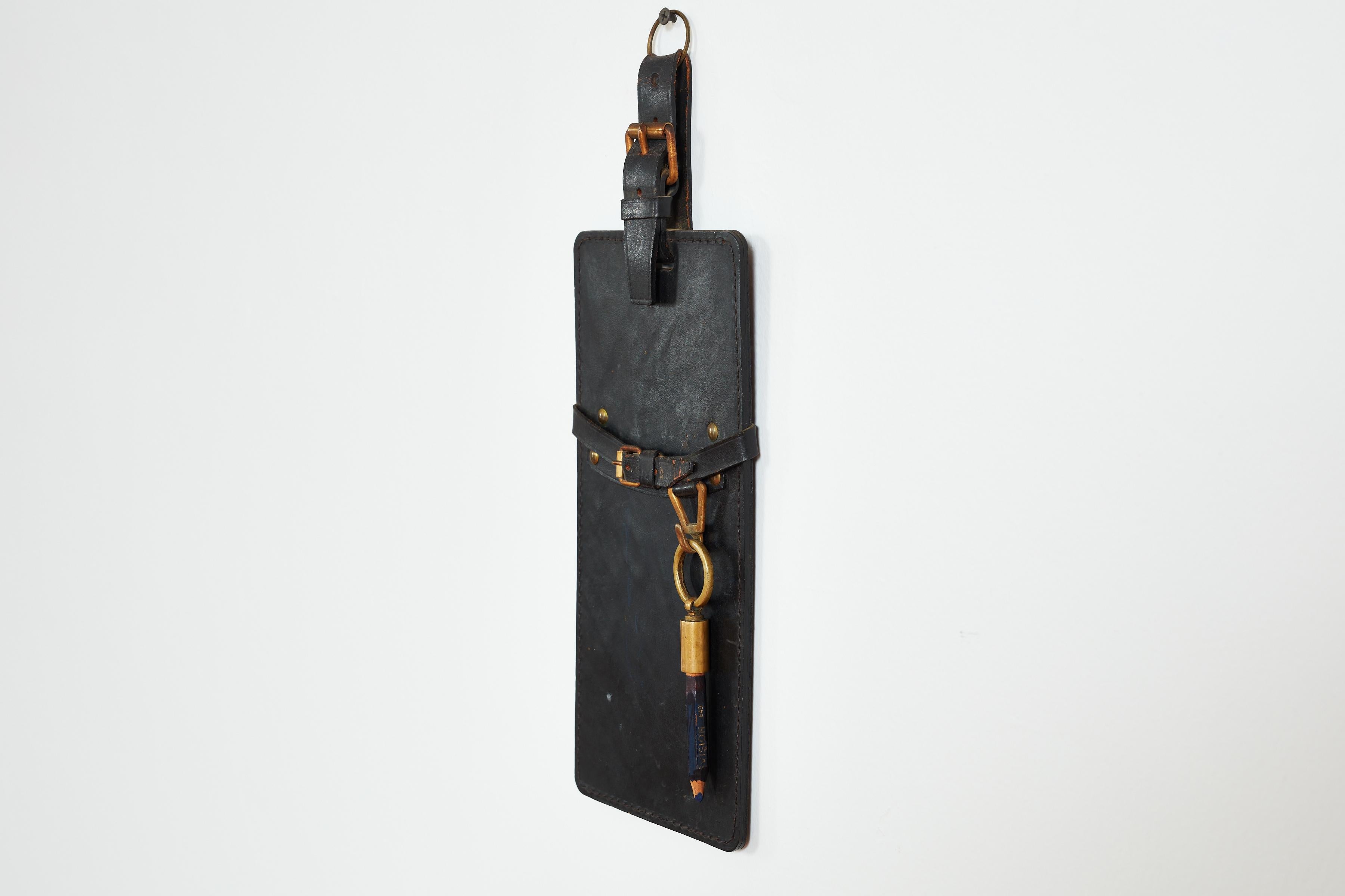 Jacques Adnet attributed wall hanging notepad holder with built in pencil. 

Notepad can slide into leather sling to write down grocery list /or notes. 

