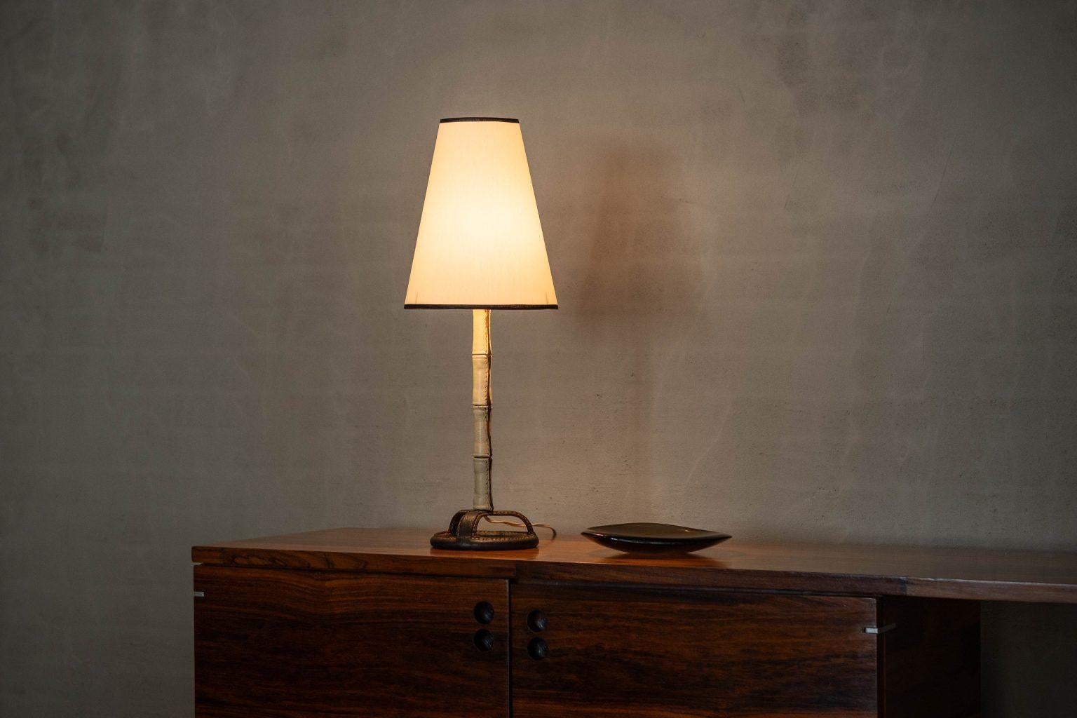 This exceptional table lamp is a masterpiece of modernist design by the renowned French designer Jacques Adnet, crafted in his atelier during the 1950s. A striking example of Adnet’s signature style, the lamp is made with luxurious and rare