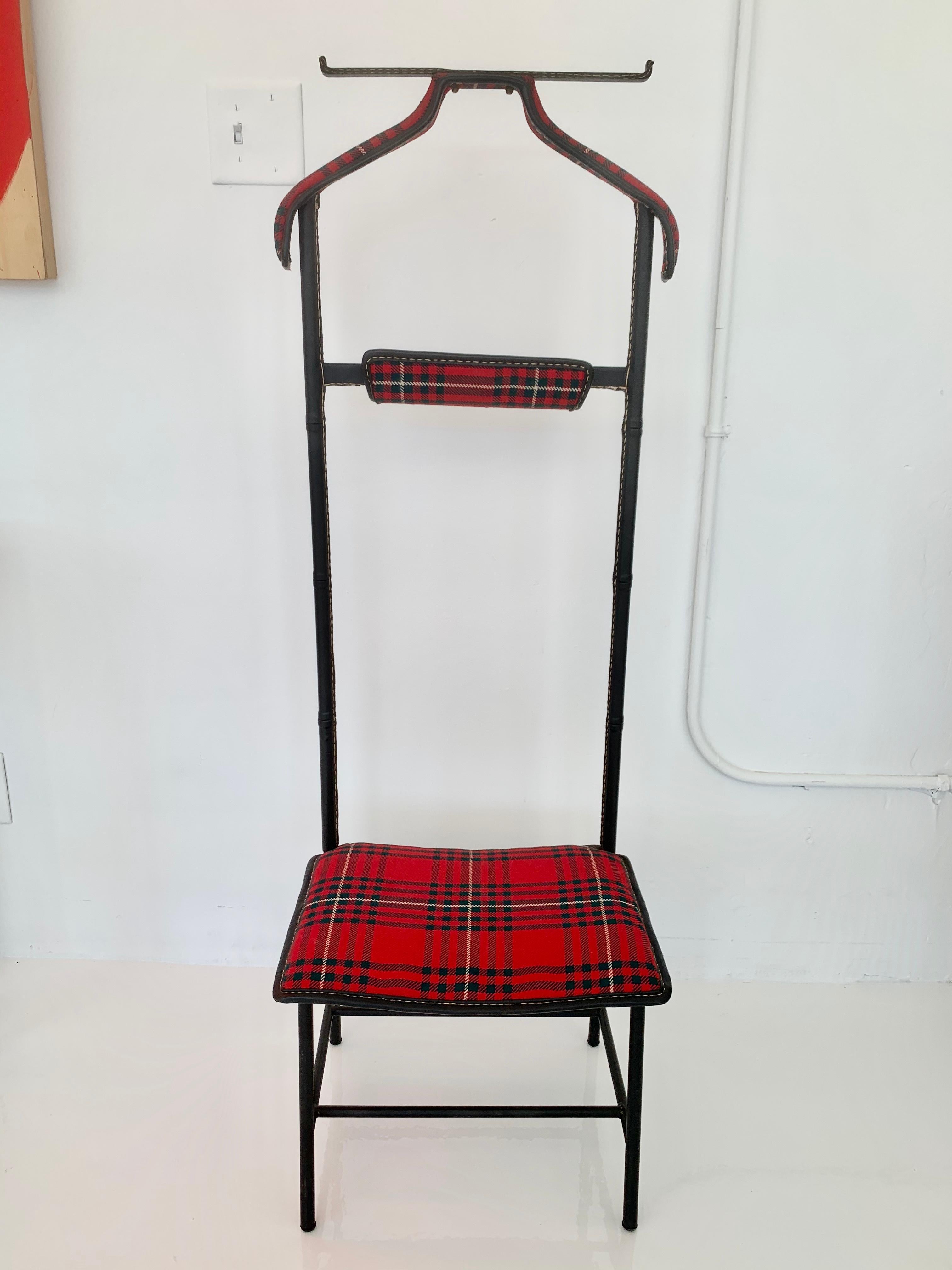 Handsome valet by French designer Jacques Adnet. Leather wrapped frame with signature Adnet contrast stitching and brass hardware. Original Tartan fabric in excellent condition. Valet features a coat Stand, pant hanger, vide poche/catchall for