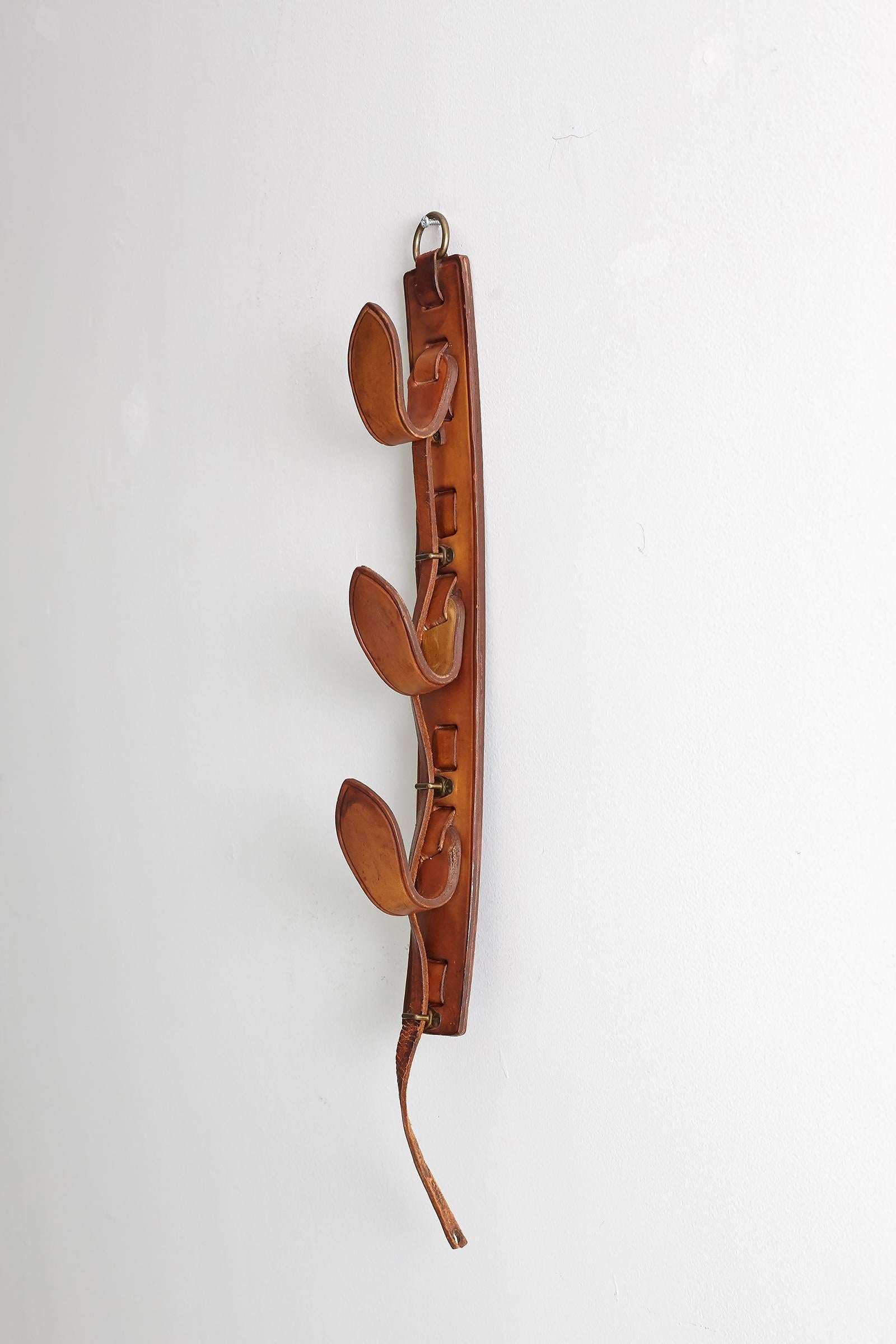 Beautiful equestrian and hunting set of three hooks on leather panel. 
 