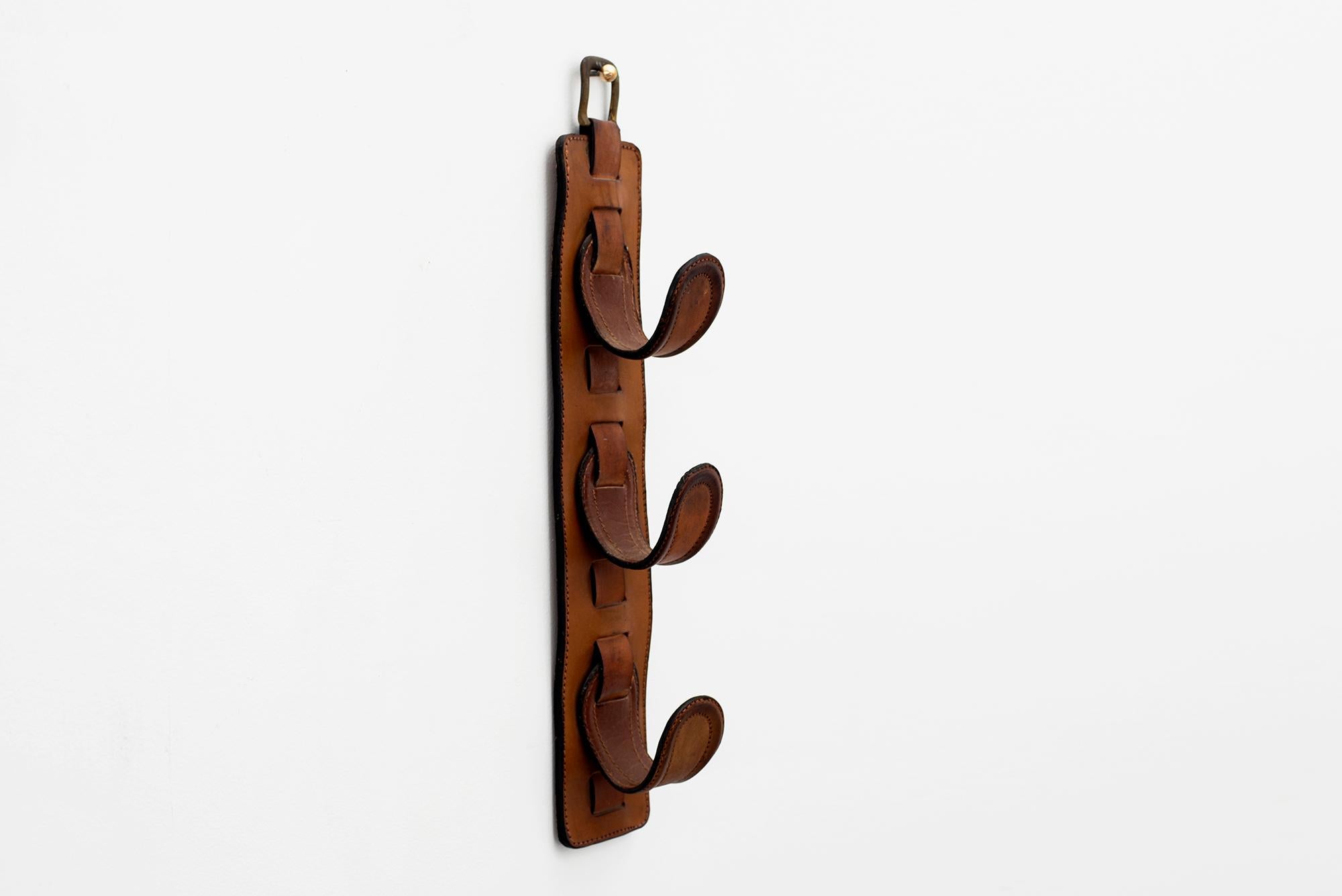 Beautiful equestrian saddle leather coat rack by Jacques Adnet
Great patina to leather.

  