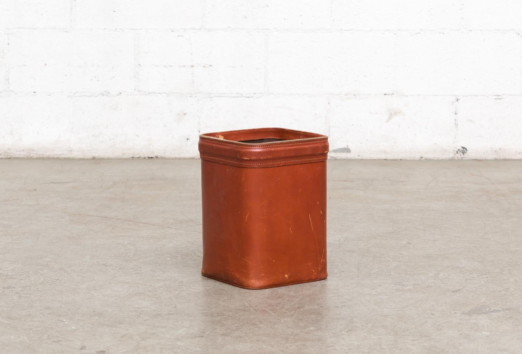 Jacques Adnet Mid-Century leather waste basket with nice patina and in original condition with visible wear consistent with its age and usage. Some denting and scratching may be present.