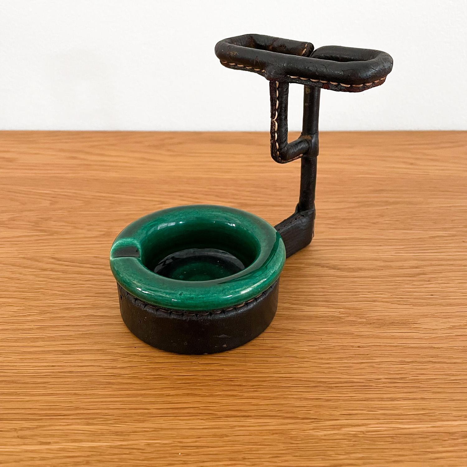 Jacques Adnet leather wrapped ceramic ashtray & cigarette holder 
France, circa 1940's 
Emerald green ceramic ashtray is free of any chips, cracks or repairs
Distressed leather wrapped cigarette carrier 
Signature contrast stitching
Patina from