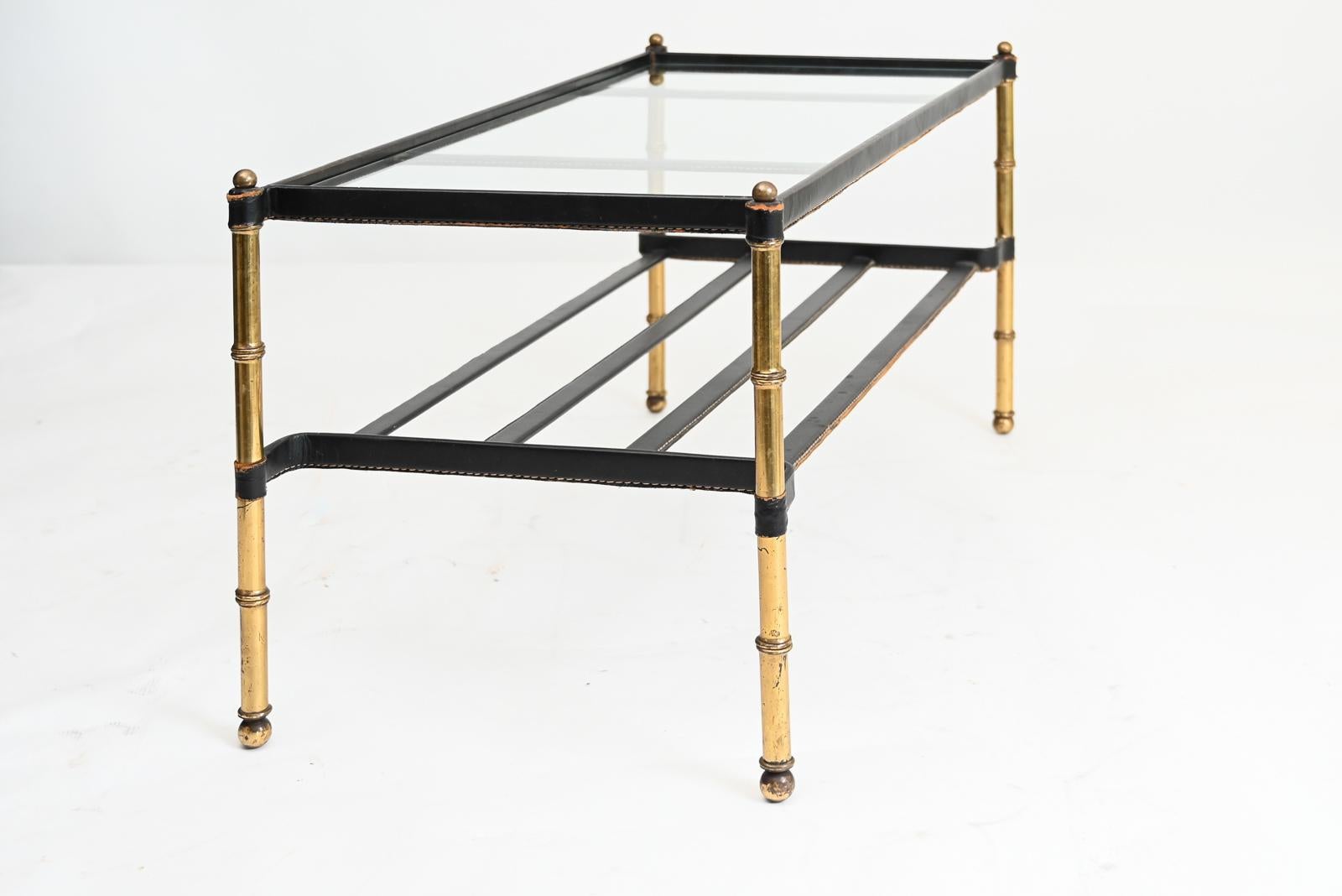Good example of a leather wrapped low table by Jacques Adnet. Brass and steel structure entirely wrapped in leather with a glass top. A rare piece with signature Adnet “pique sellier” saddle stitching, France, circa 1950-1960.
   