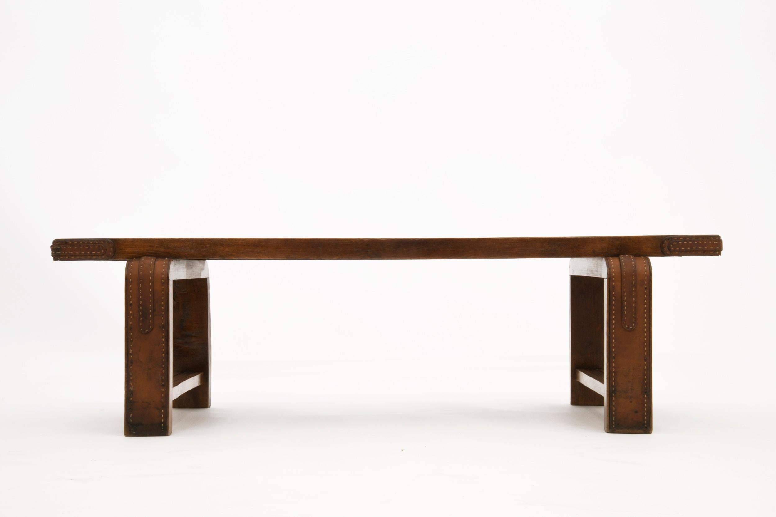 Beautiful luggage bench by Jacques Adnet, which could also be use as a coffee table, in oak detailed with stitched leather in legs and corners.