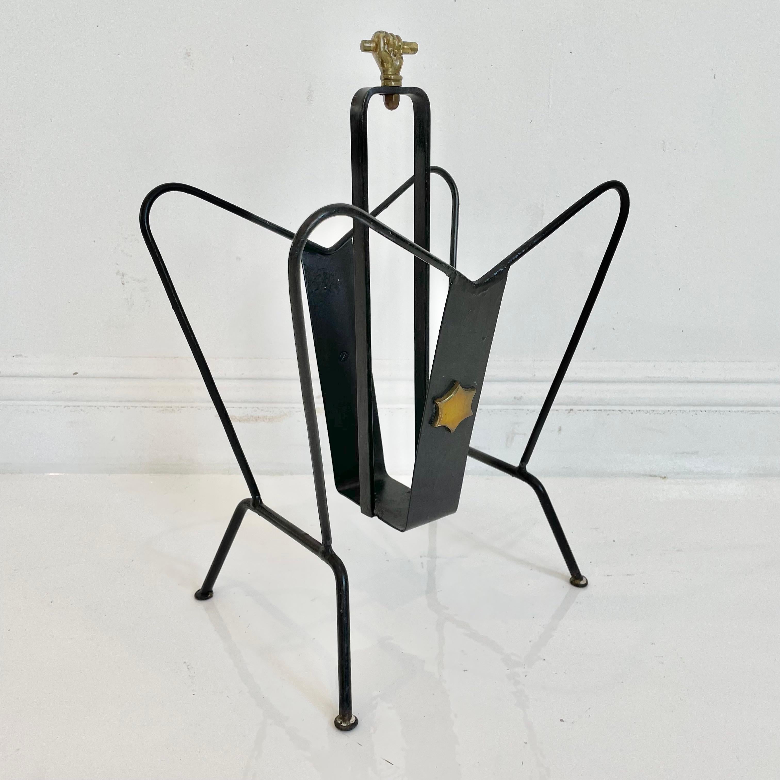Handsome magazine rack by Jacques Adnet. Made of iron and brass. Excellent vintage condition. Star detail on both sides and closed fist on top. Great piece!