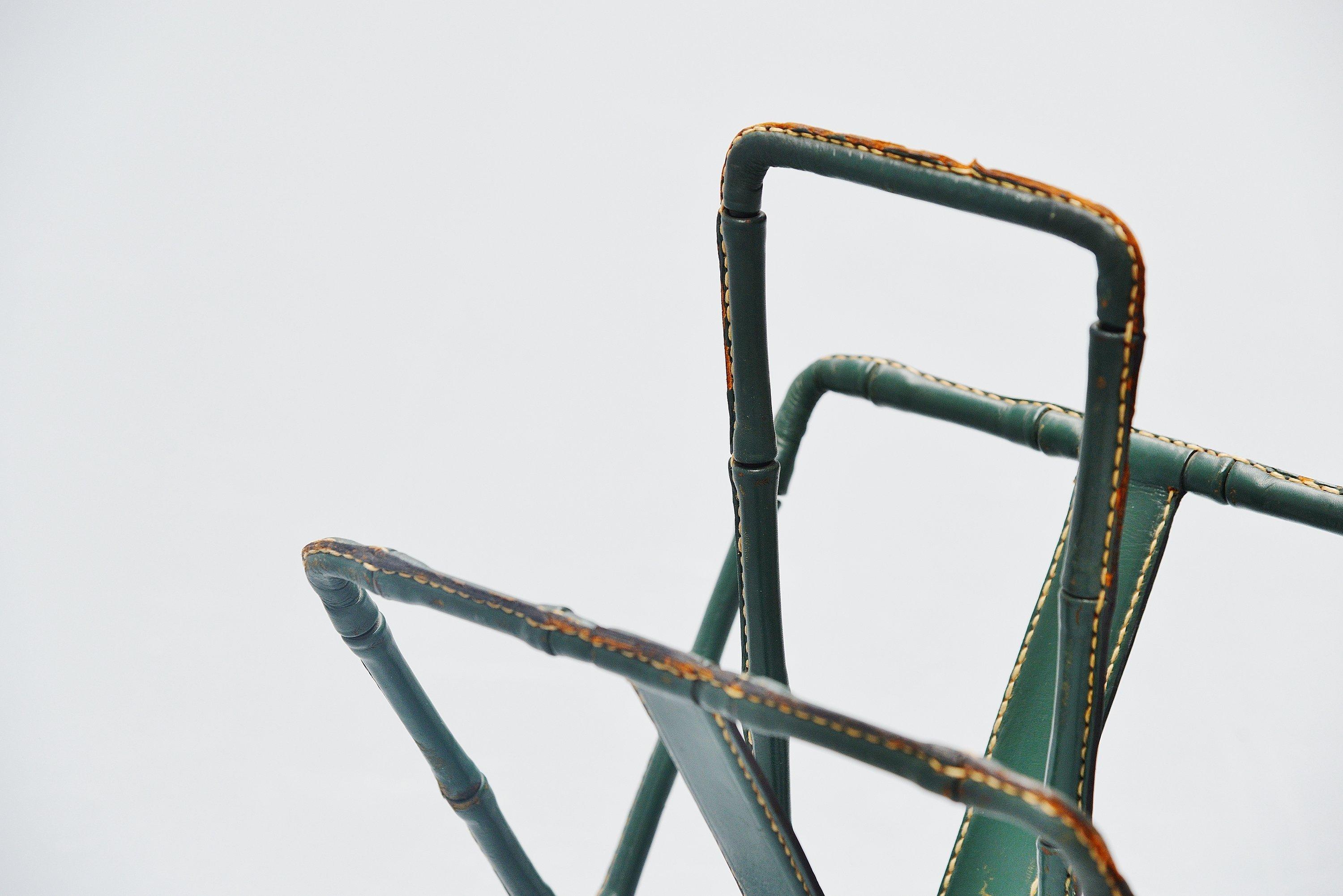 Magazine stand designed by Jacques Adnet and manufactured in his own atelier, France, 1950. The magazine stand has a solid brass frame and is fully covered with handstitched green leather. The stand has a nice patina from age and usage, and is fully
