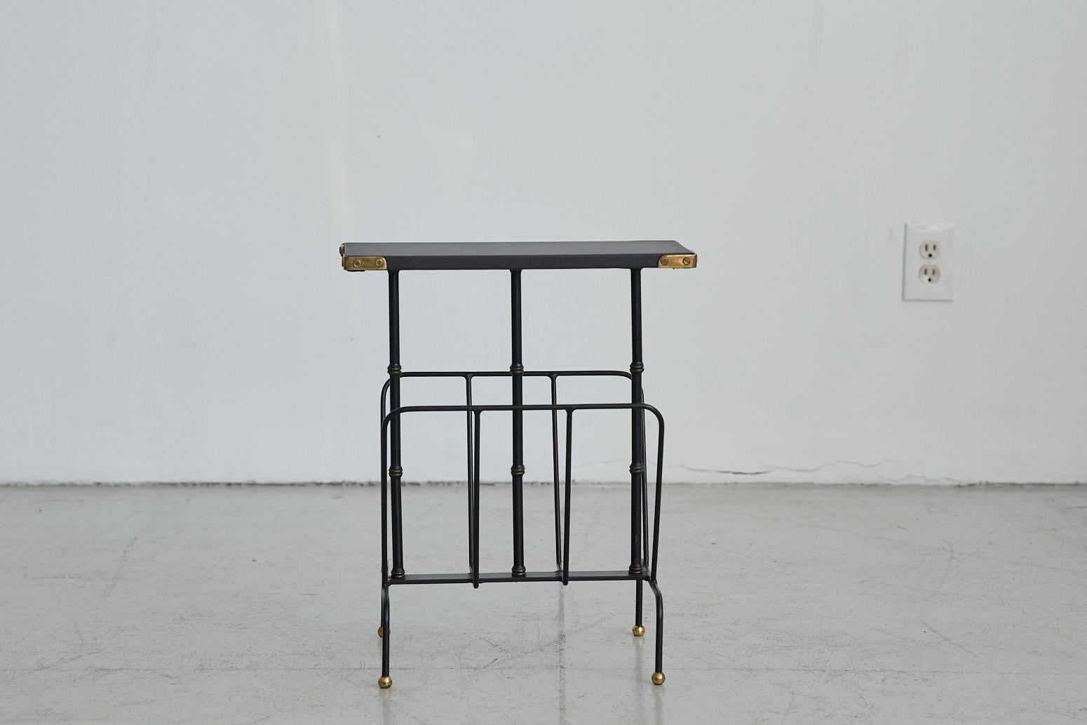 Jacques Adnet magazine table with magazine rack. Black skai leather top, signature brass and black bamboo legs, with iron frame and brass corner detail.
