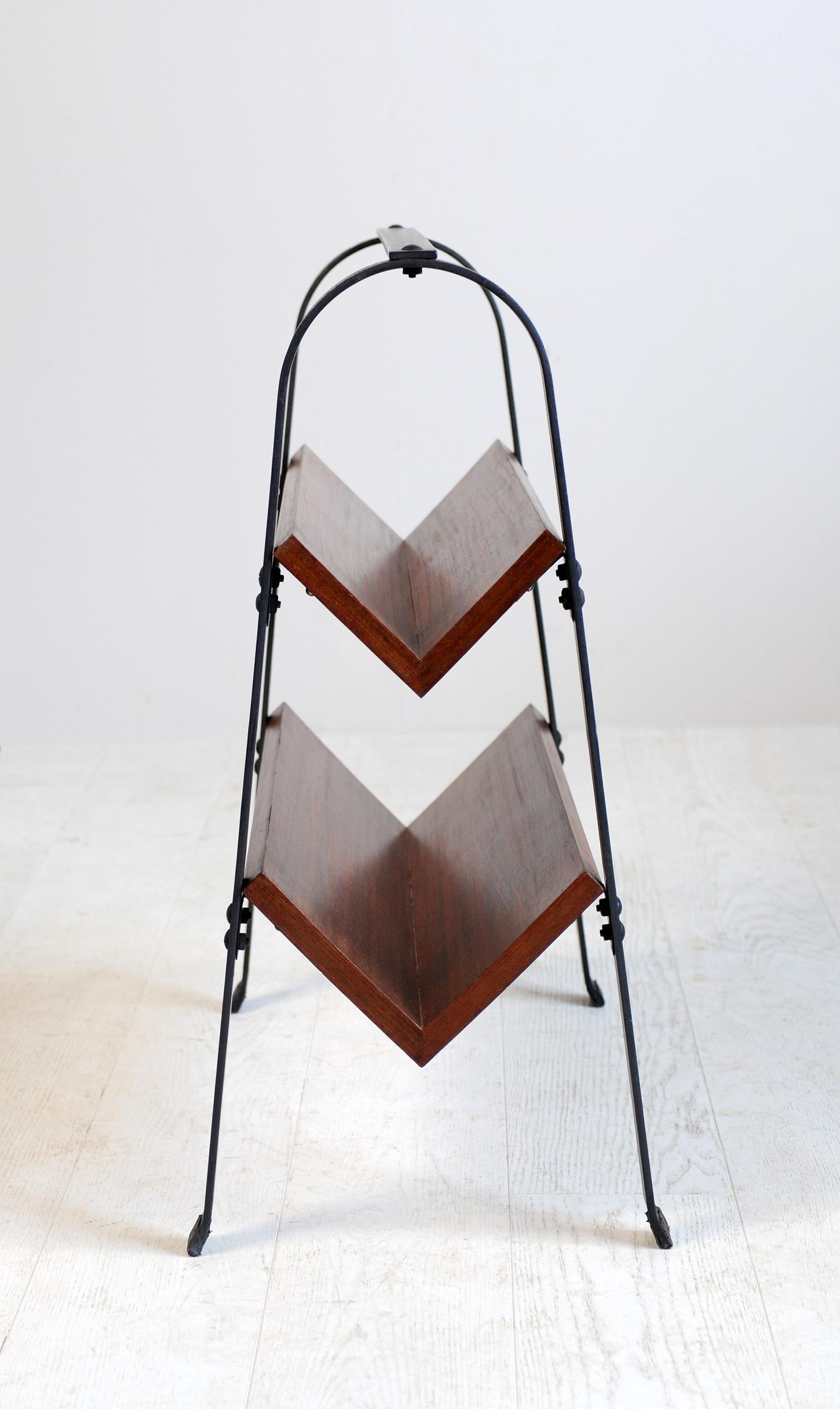 Jacques Adnet, bookcase in solid mahogany and blackened flat iron, France, 1950. The steel blade structure receives two shelves assembled in a V-shape, slotted bolts form the backdrop. Leather pads are placed on the 4 feet. Very good condition.
  