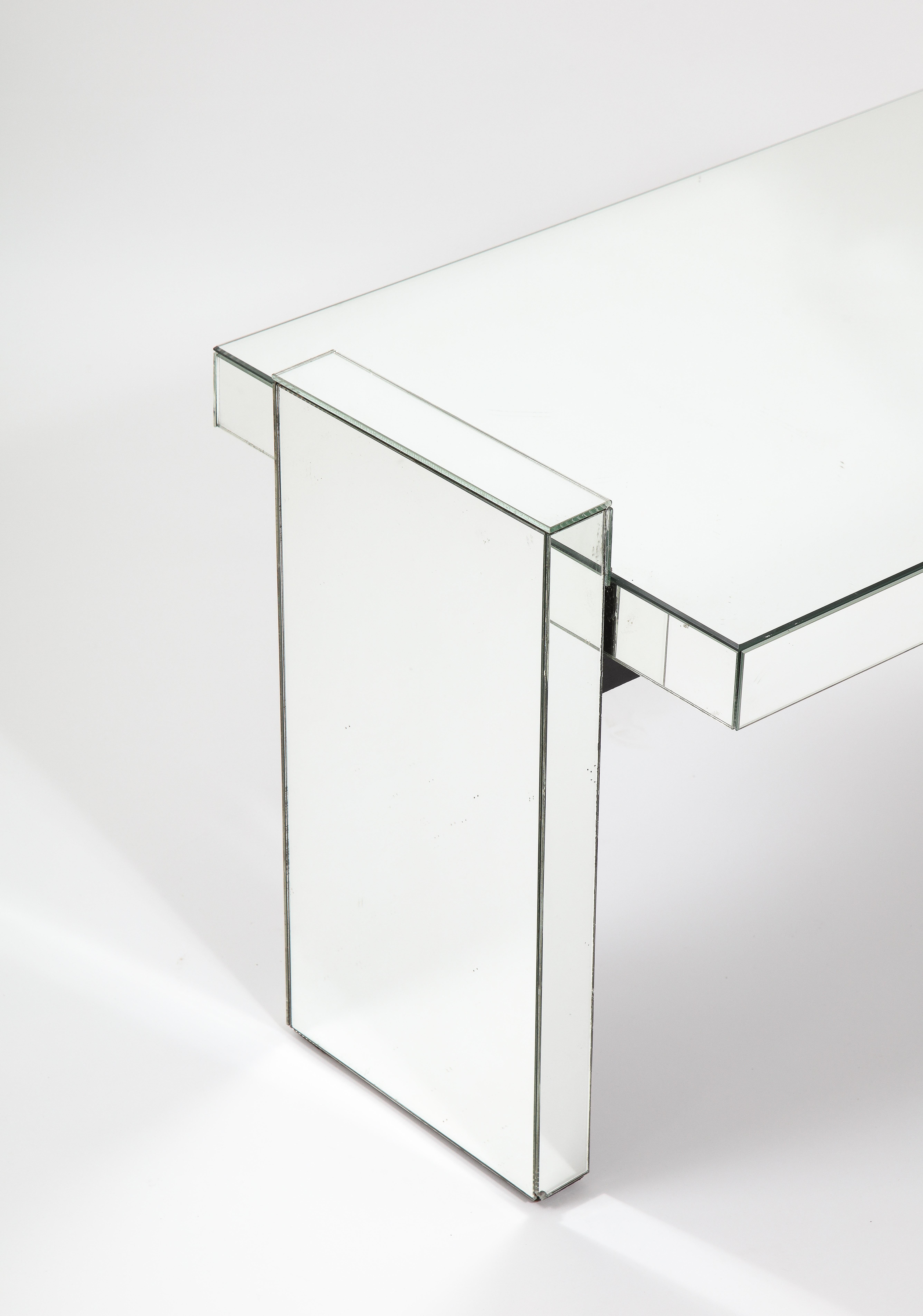 Ein Spiegeltisch von Jacques Adnet in der klassischen Sprache des Künstlers, eine einfache, aber starke Form, die mit Spiegeln verkleidet ist.