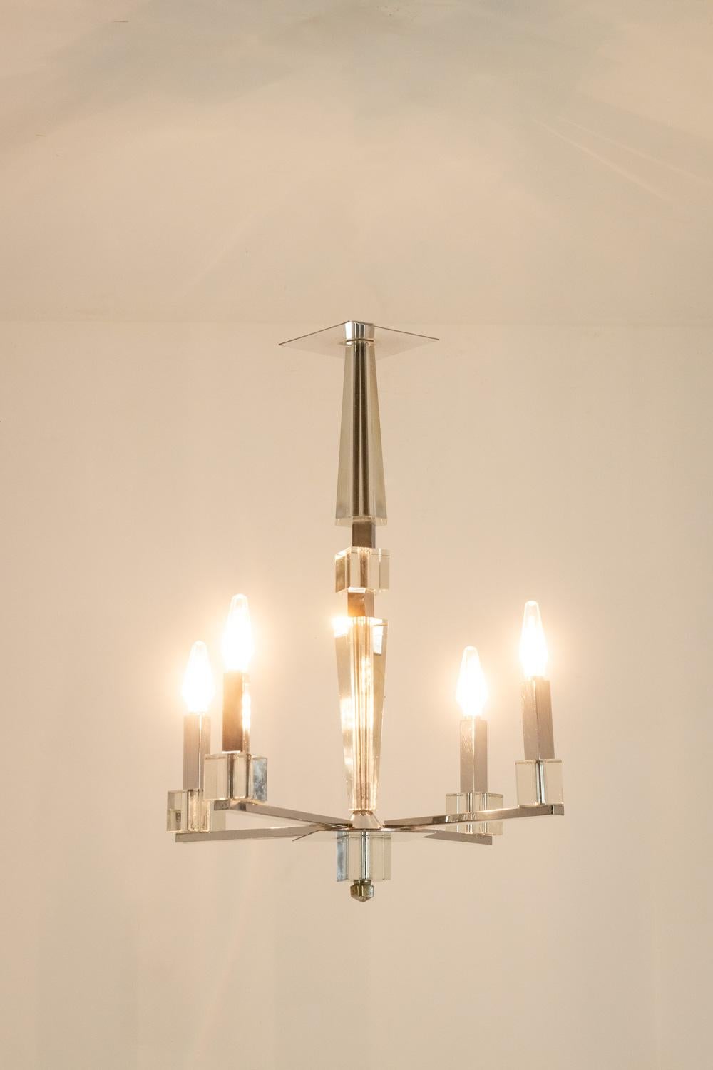 Jacques Adnet, in the style of.

Modernist chandelier in chrome metal and faceted glass, with 4 arms of light.

French work realized circa 1940.

Dimensions: H 60 x W 47 x D 47 cm

Reference: LS6042309H