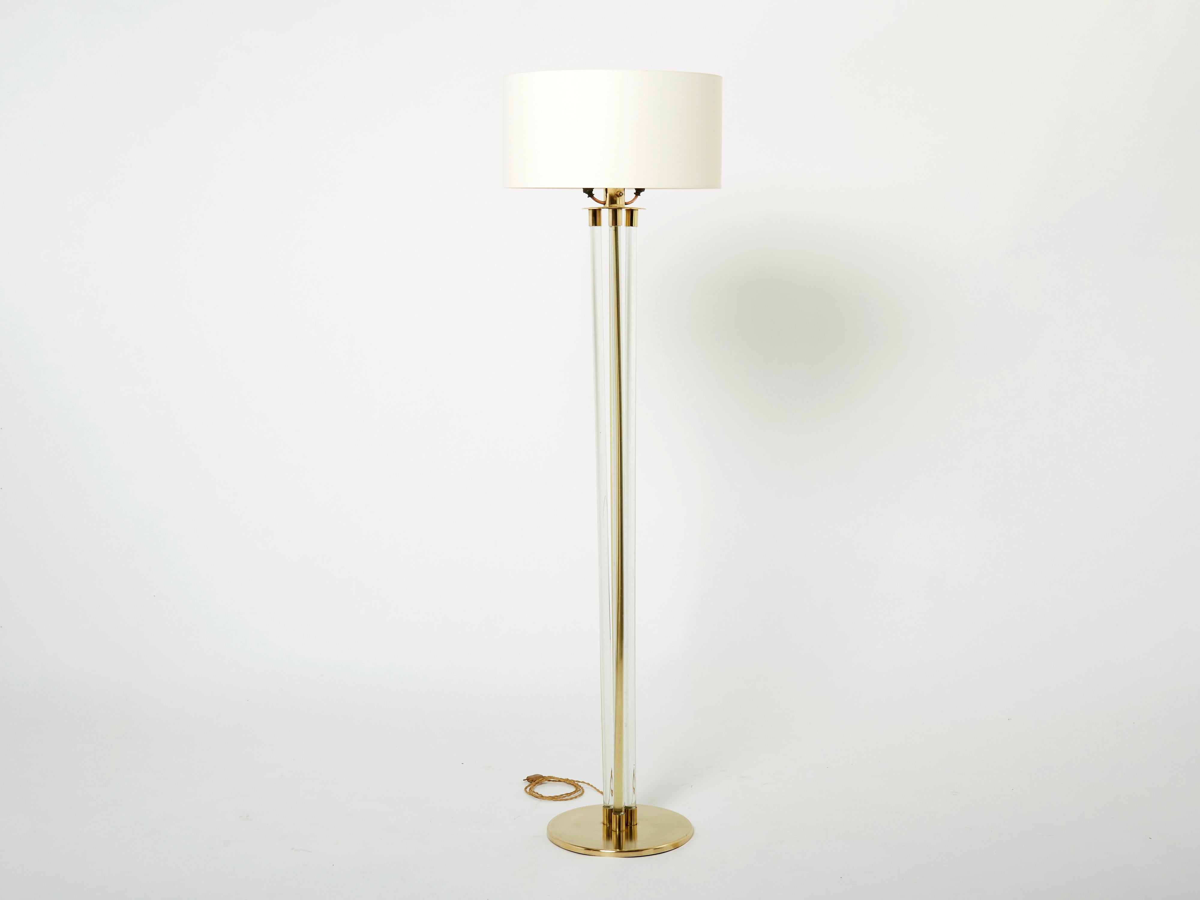 This beautiful Jacques Adnet floor lamp is sure to add an element of French modernism to any room in your home. It was designed and produced by Jacques Adnet in the early 1950s. With a solid brass structure and rounded feet, three lucite tubes going