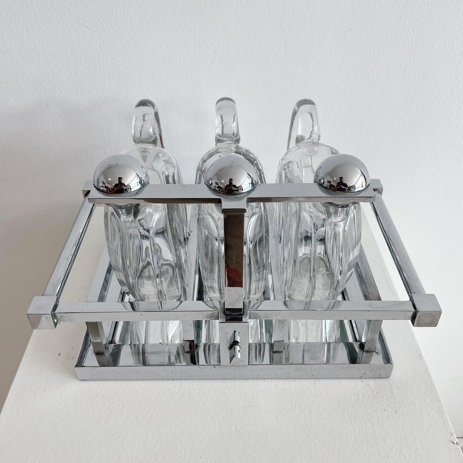 A very rare modernist chromed metal & faceted crystal tantalus by Jacques Adnet and Baccarat, circa 1930. Three Baccarat crystal decanters, signed under each.
Lockable latch to secure the decanters.