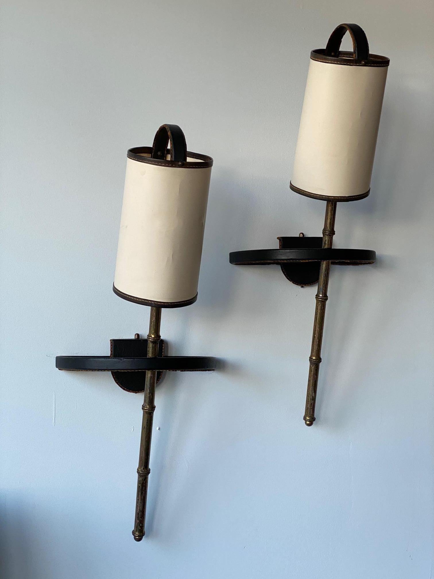 A pair of sconces / wall lamps by French Art Deco Modernist designer, architect, and interior designer, Jacques Adnet. A beautiful set of lights in leather and brass with paper shades.
Acquired from DeLorenzo 1950, New York, by the present owner,