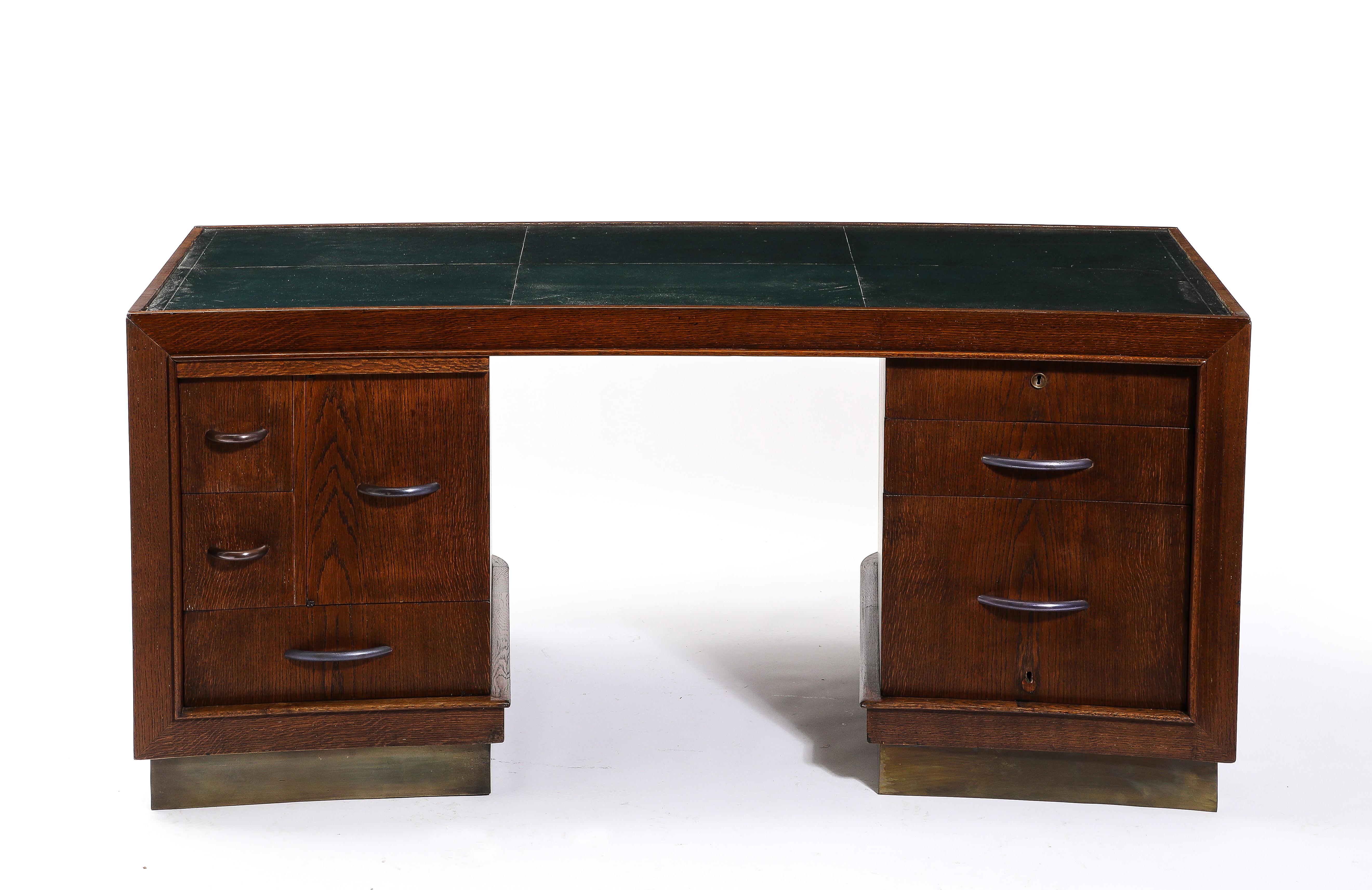 “President” Oak Desk on drawer pedestals and brass plinth, copper handles with original British green leather top, details abound in this piece such as the guest facing end with its intricate moldings and the curved sides of the pedestals
Similar