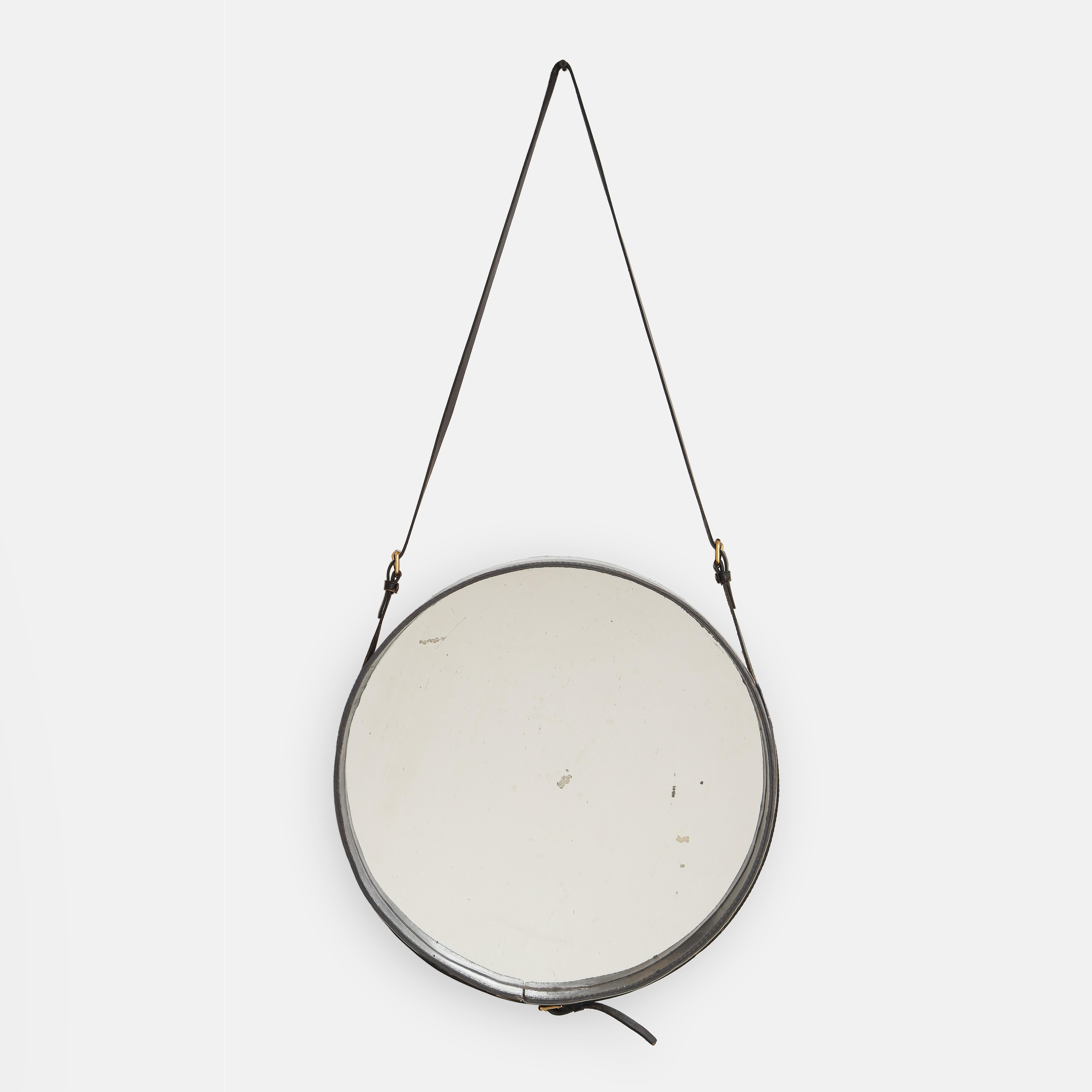 Jacques Adnet rare original round wall mrirror clad in black leather with adjustable straps and original mirrored glass, France, 1950s. This mirror has remained in completely original and very good condition with no significant damage or tears in