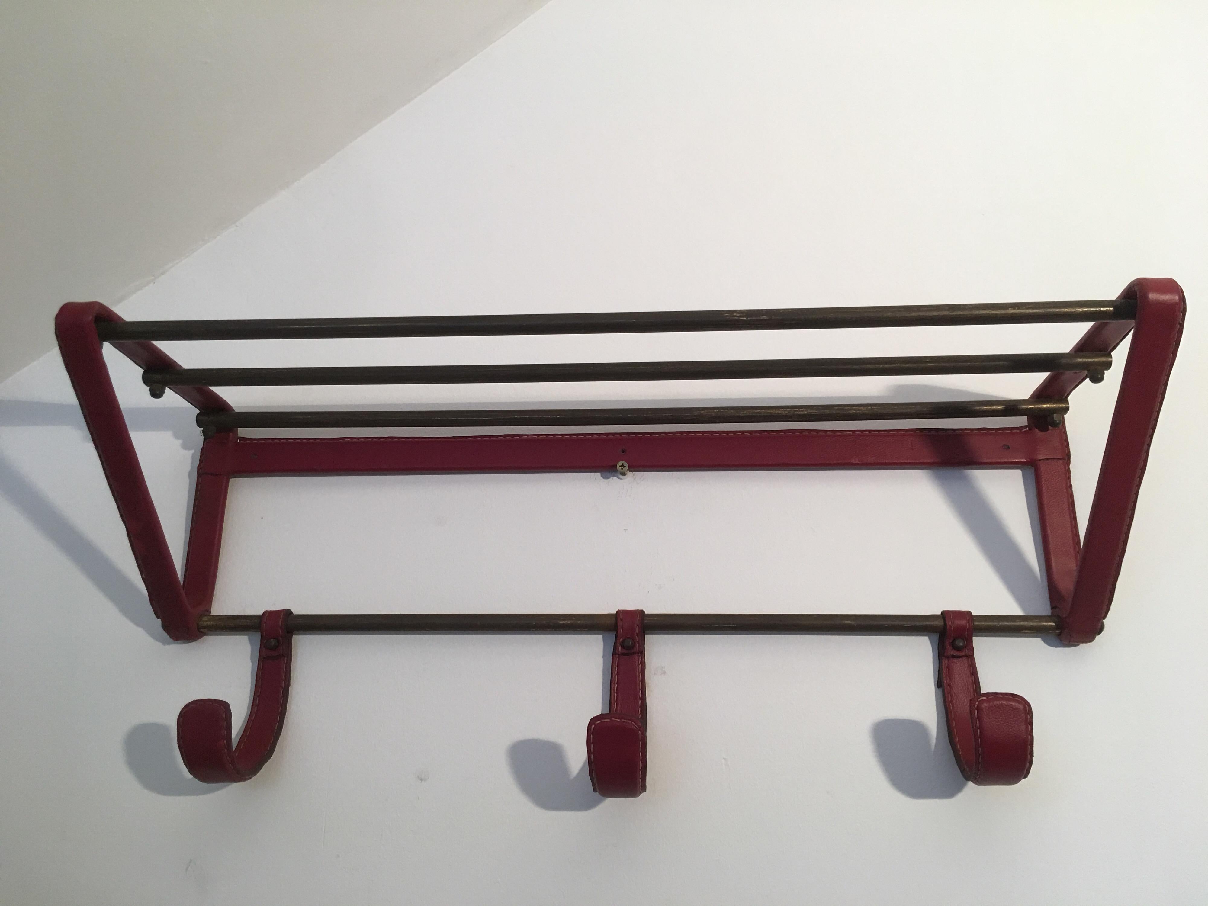 Red stitched leather coat rack and brass hat rack, designed by jacques Adnet in France in 1950s.
Rare and beautiful red color of the original leather.
Minor scratches on the original leather but nothing unsightly.
Vintage patina on all brass