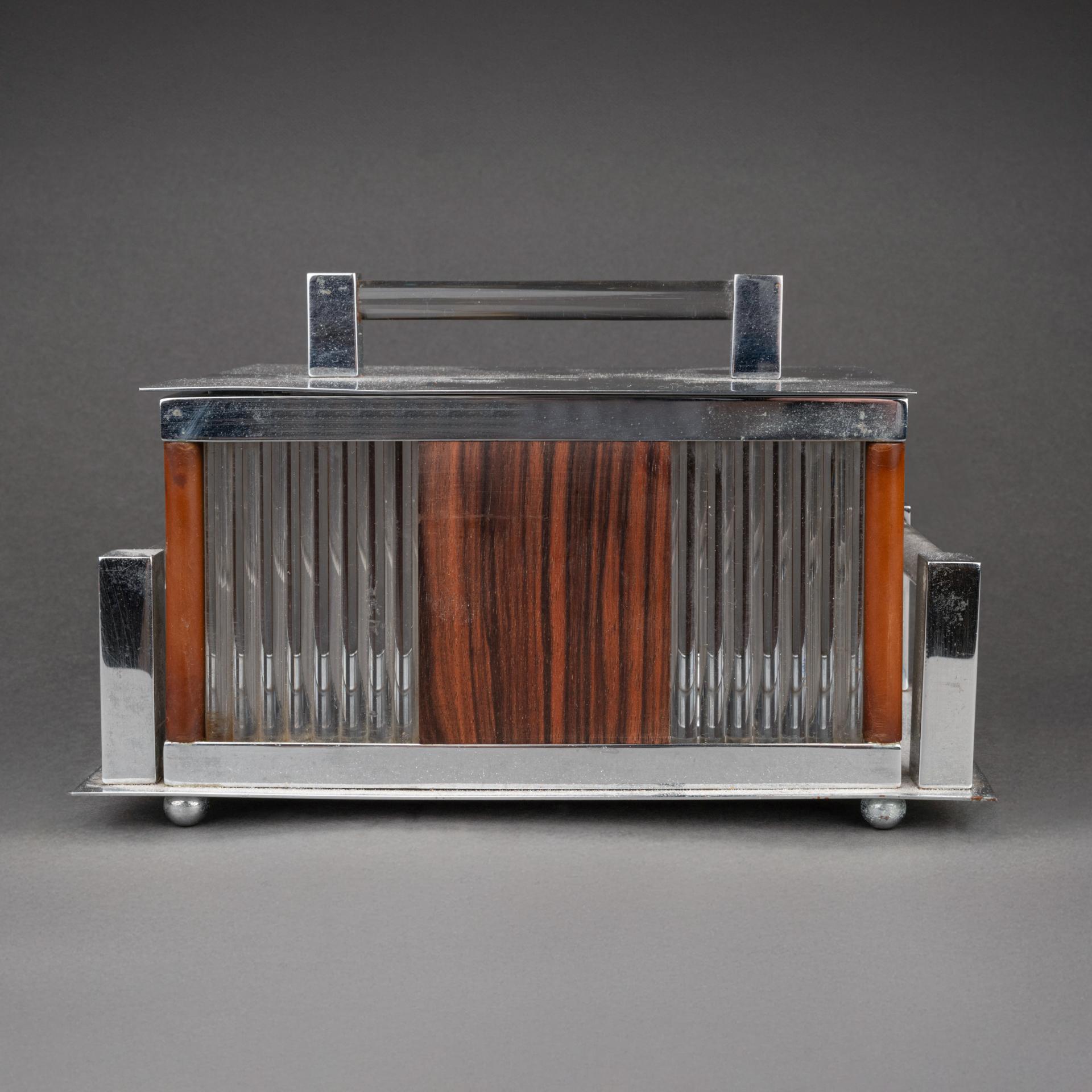 Jacques Adnet (1900-1984, Francia) : Caja modernista de palisandro, cristal y metal cromado 

Hacia 1930, Francia

Dimensiones 
Altura = 12 cm
Anchura = 20 cm
Profundidad =12 cm

Procedencia : procedente de un encargo privado de un decorador a