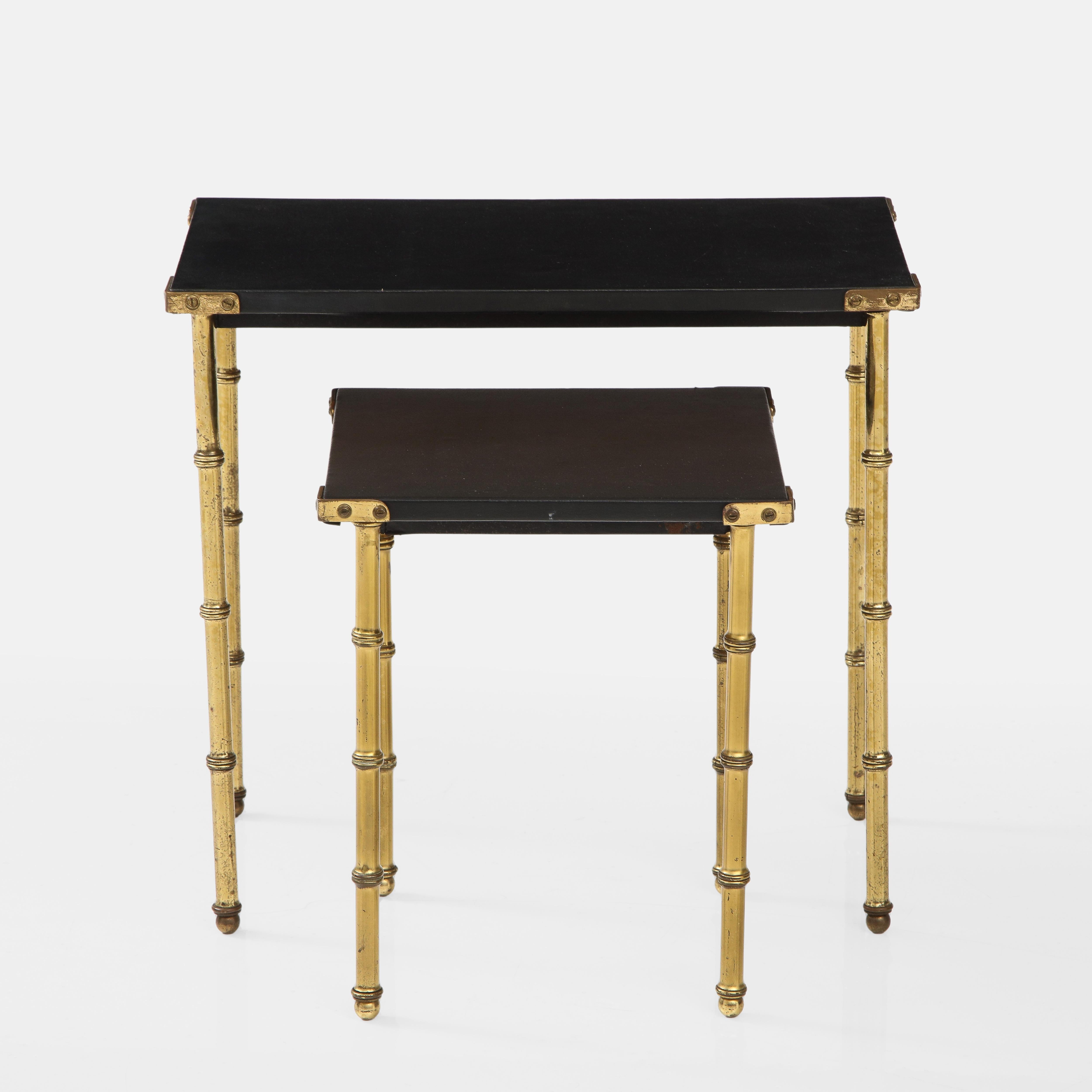 Jaques Adnet original set of faux bamboo side nesting tables with tops wrapped in original black skaï and faux bamboo brass legs. These side or end nesting tables have remained in completely original and very good condition and are free of tears or