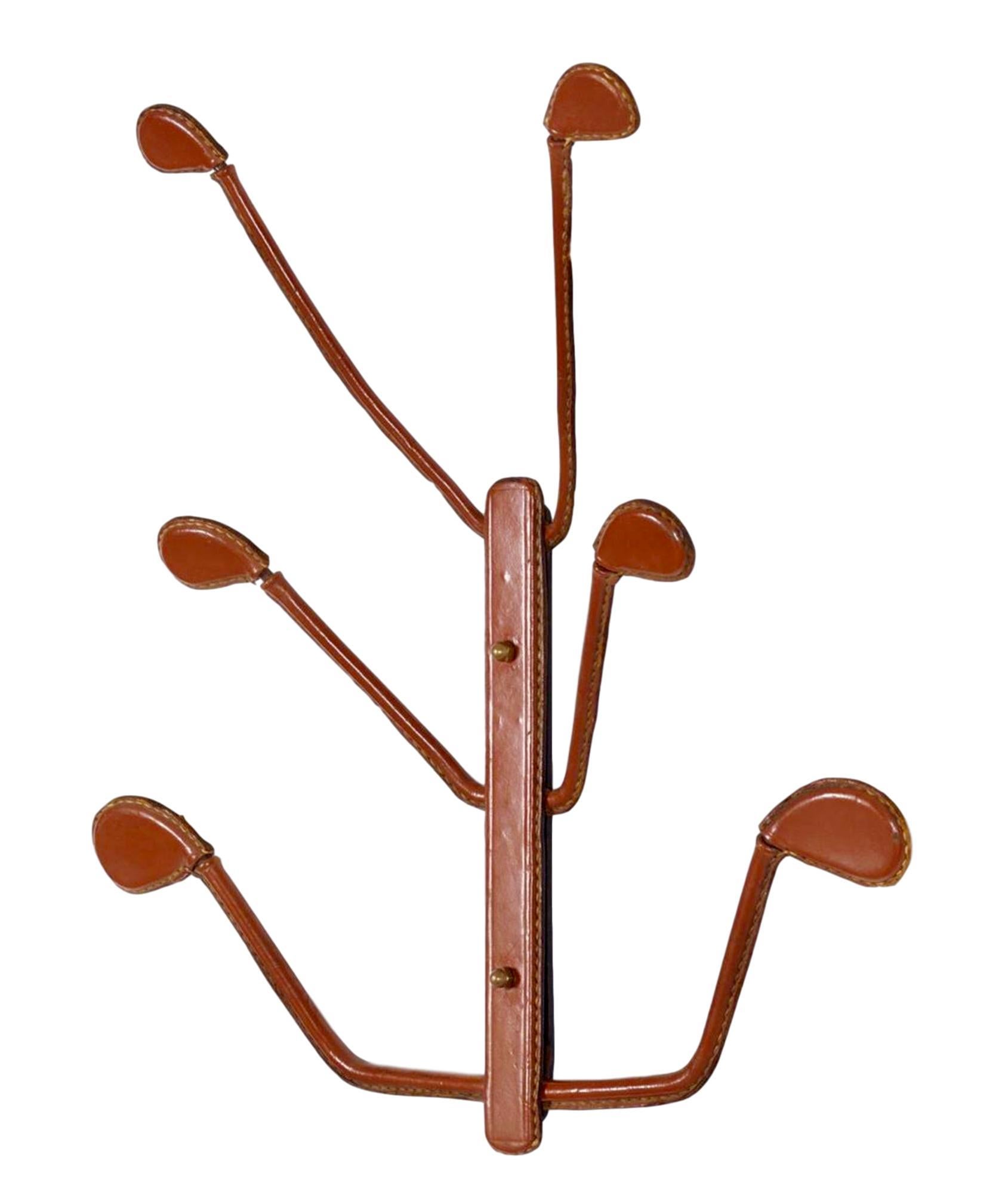 Classic coat rack by French designer Jacques Adnet. 6 leather arms extend from center bracket. Large presence, just under 2 feet wide and tall. Entire piece is wrapped in leather with signature Adnet contrast stitching. Great vintage