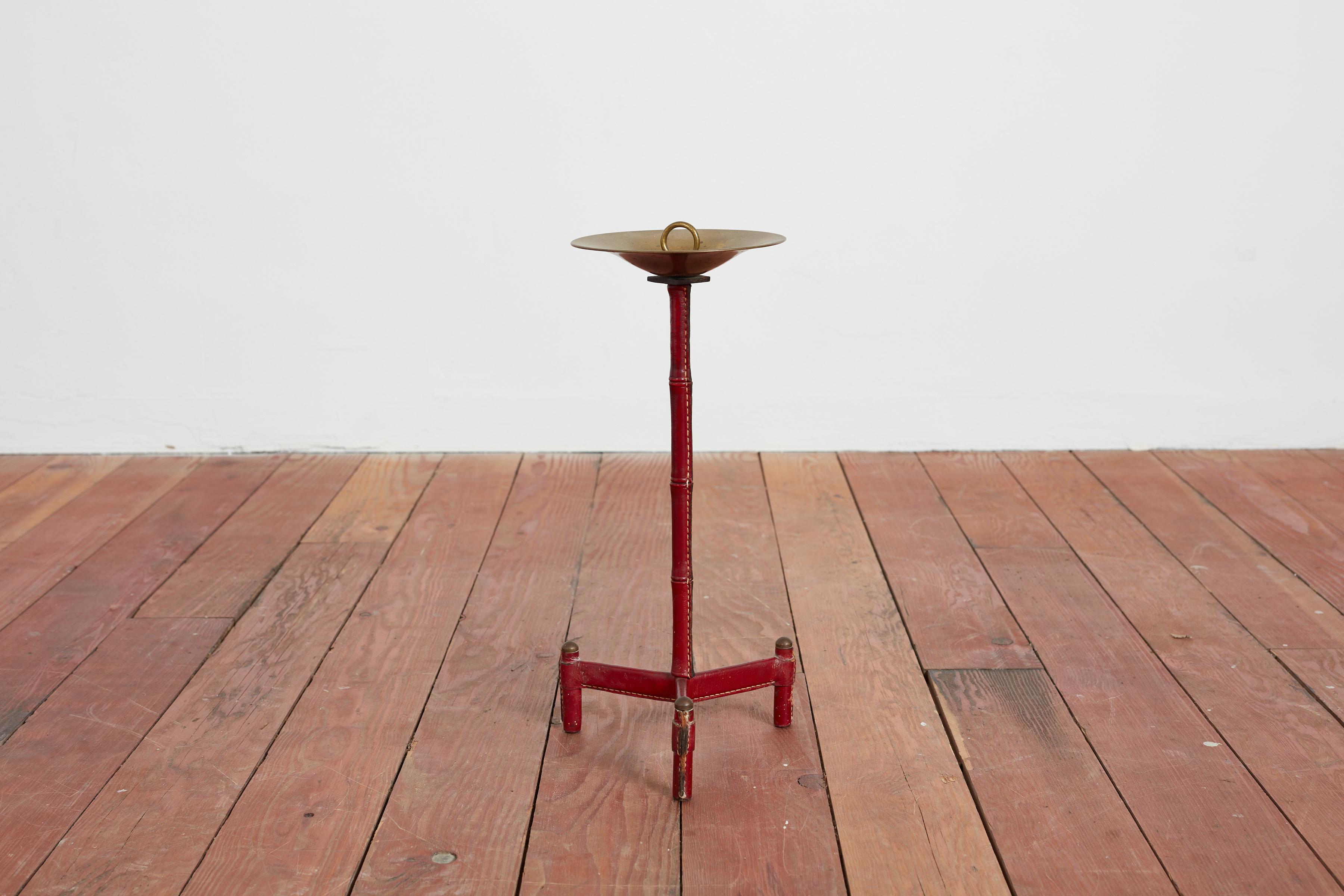 Jacques Adnet standing ashtray with red leather tripod base and signature contrast stitching - bamboo stem with brass catchall .
Great patina.

France, 1940s