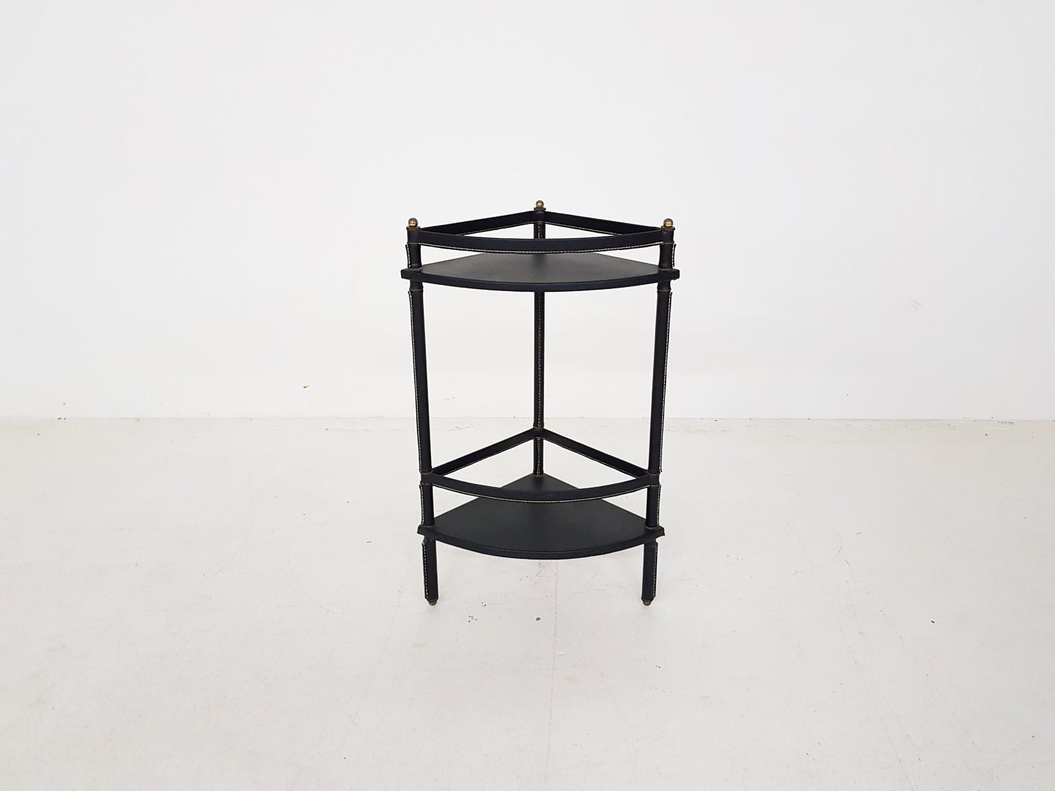 A side or corner table in stitched leather with brass details. Designed by the legendary French luxury designer Jacques Adnet in the midcentury.

This piece is from his stitched leather series which he created in the 1950s. This series consisted