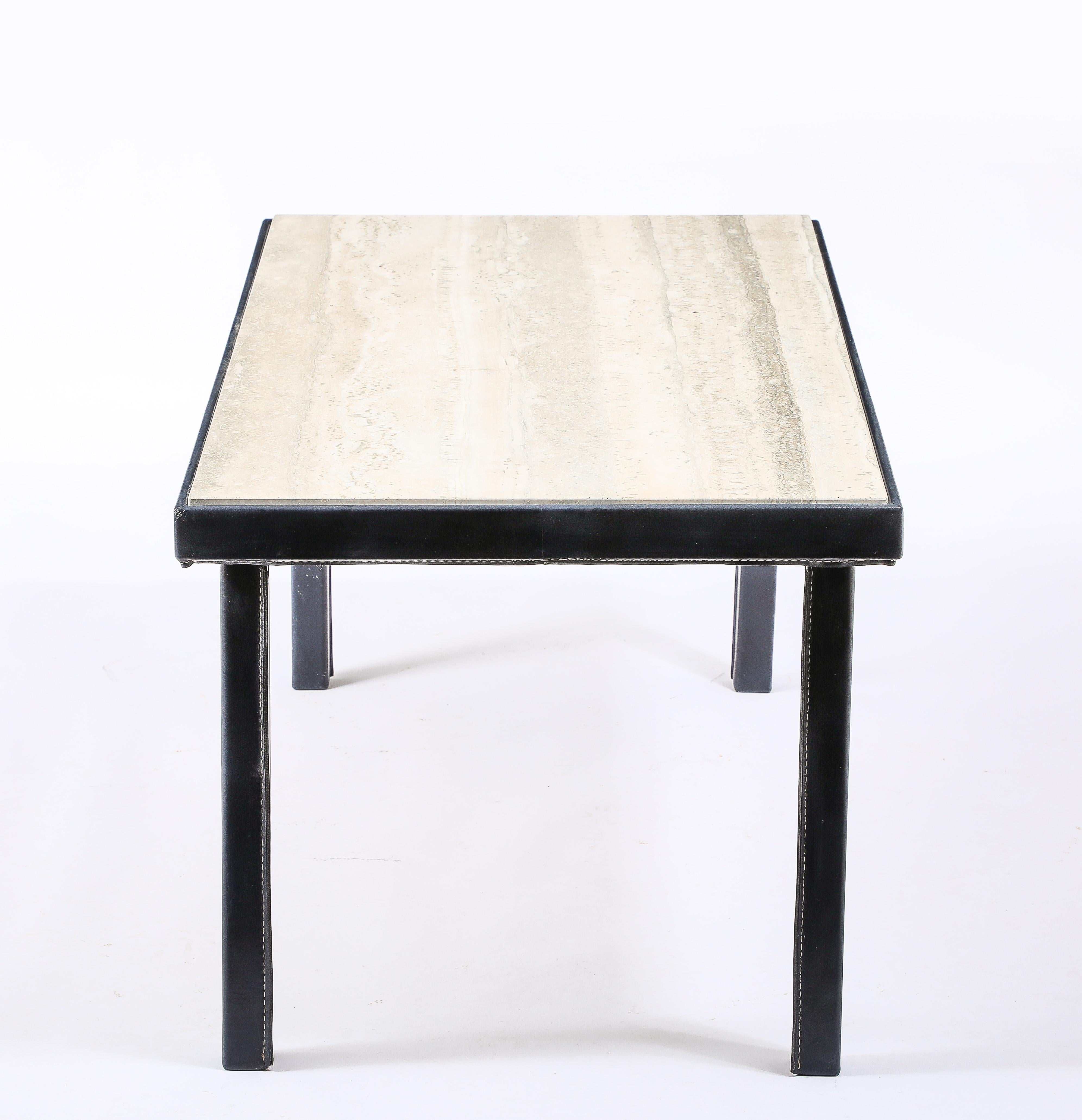 Stitched blue leather and travertine table in a simple yet elegant and handsome form, each leg stitched at the inward angle and the apron stitched in the bottom with the travertine rising slightly from the frame.
