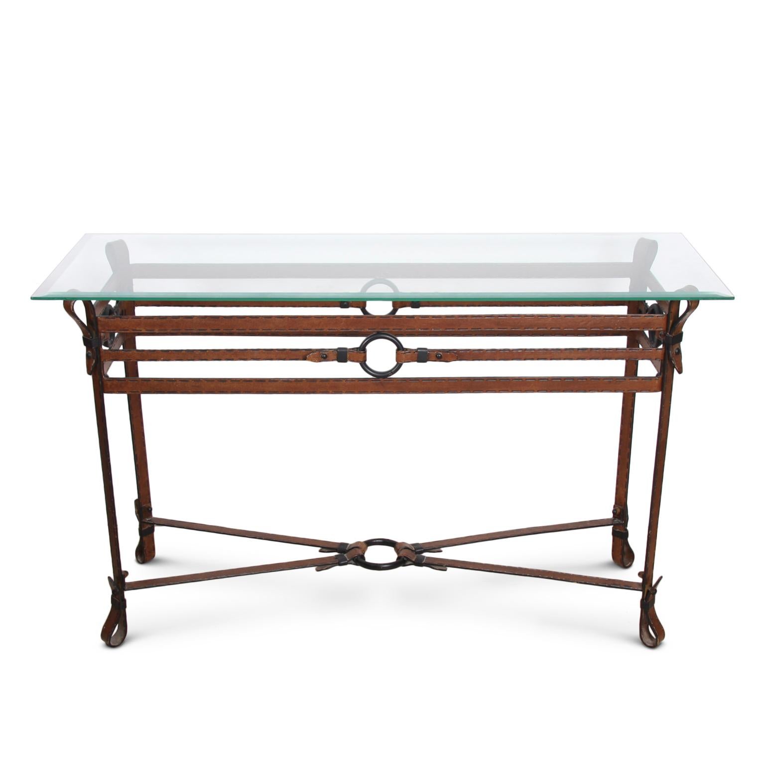 A handsome metal strap console table in the style of Jacques Adnet dating to the 1970s with painted leather and stitch detail.