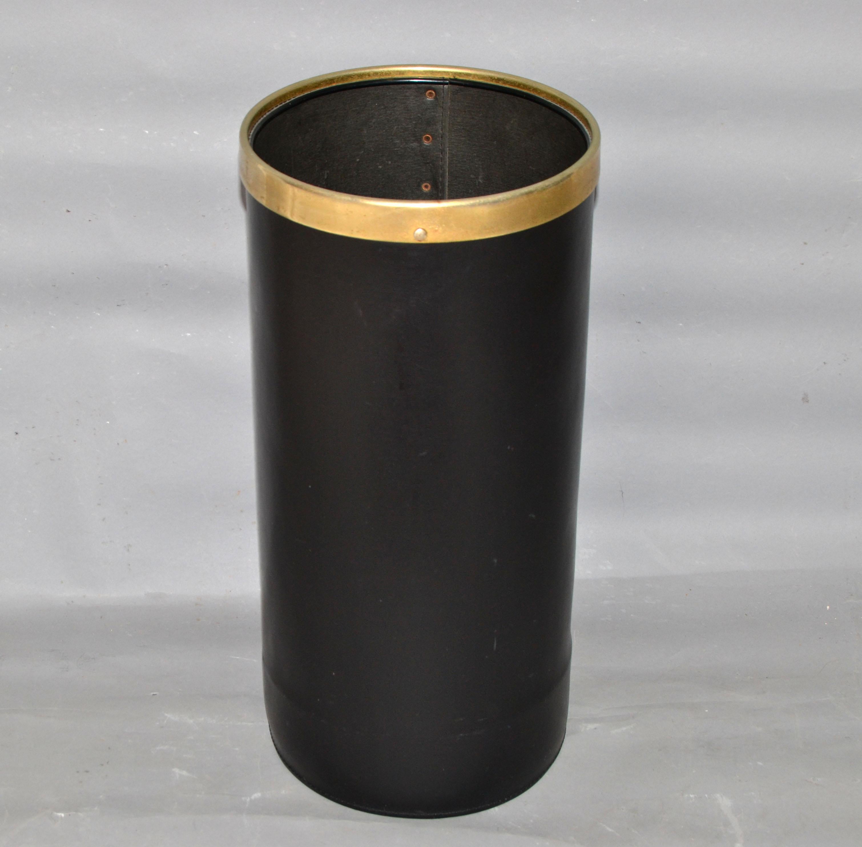 Jacques Adnet style Mid-Century Modern waste basket or umbrella stand in faux leather with brass border and studs.
It was made in France in the late 1950s.
As Minimalism as practical.