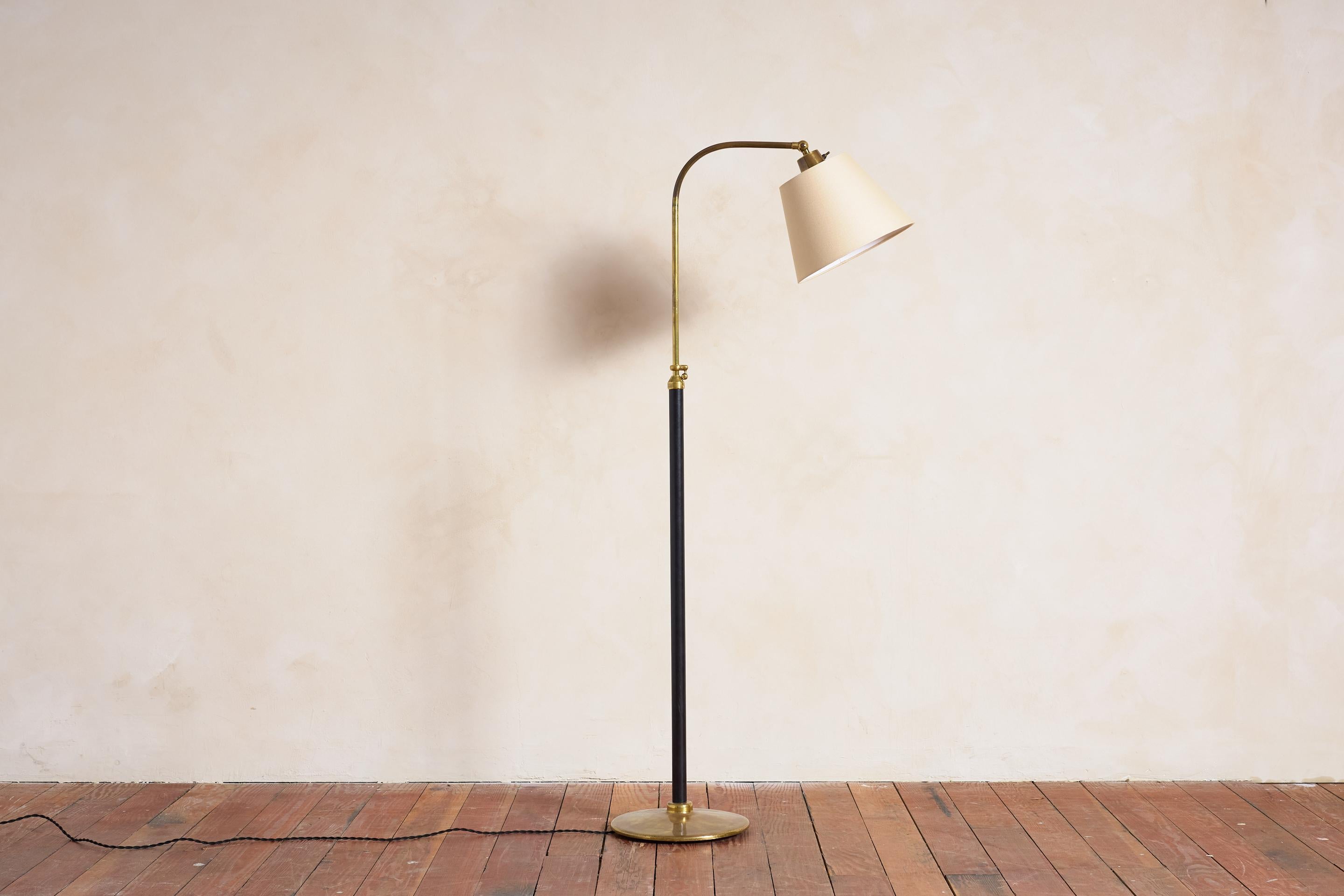 Jacques Adnet style floor lamp in black leather with contrast stitching 

Polished brass round base and hardware with adjustable height mechanism

New linen shade

Lamp Height adjusts  50.25