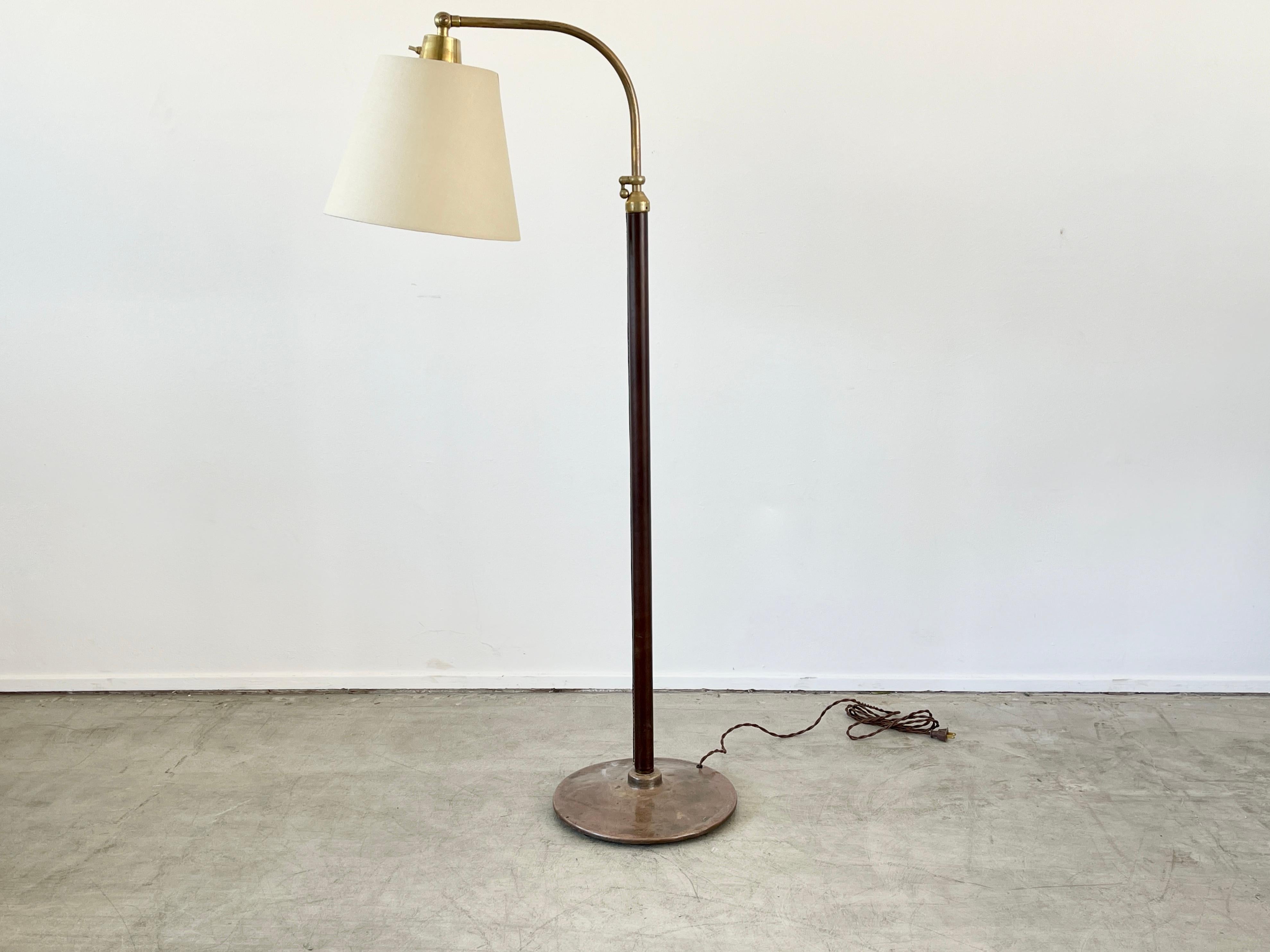 Jacques Adnet style floor lamp with dark brown leather and brass circle base and brass hardware.
Signature contrast stitching - newly rewired and new silk shade.