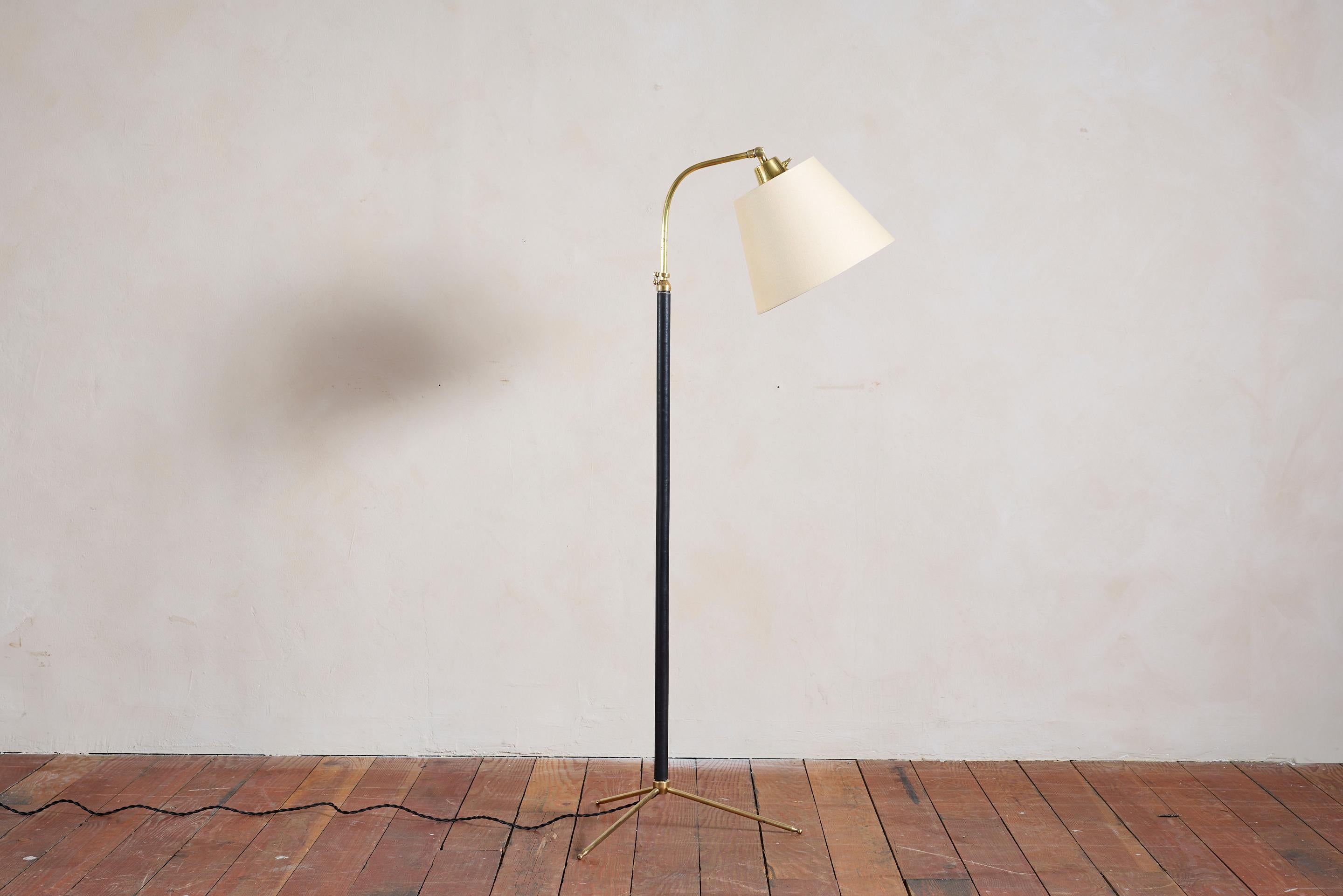 Lampadaire français de Jacques Adnet avec cuir noir cousu main, surpiqûres contrastées, base tripode en laiton et abat-jour en soie neuve. 

Nouvellement recâblé.

La hauteur s'étend de 50,25
