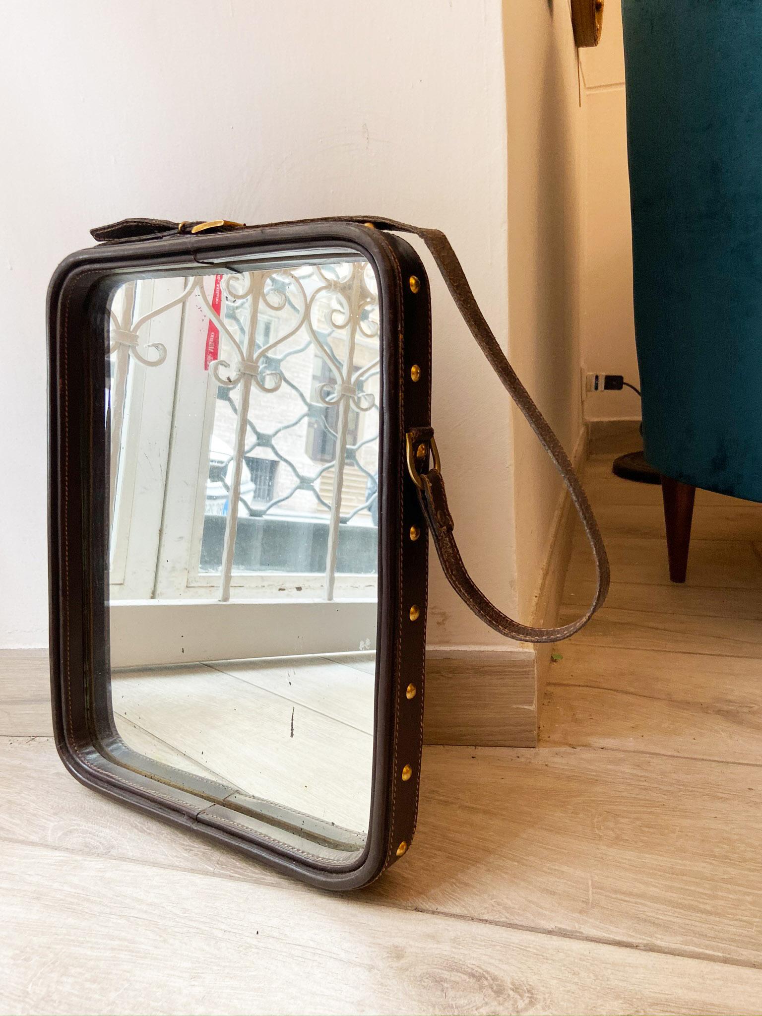 Rectangular wall mirror with frame covered in leather. 
Leather belt with hanging buckles.
Excellent condition.
 