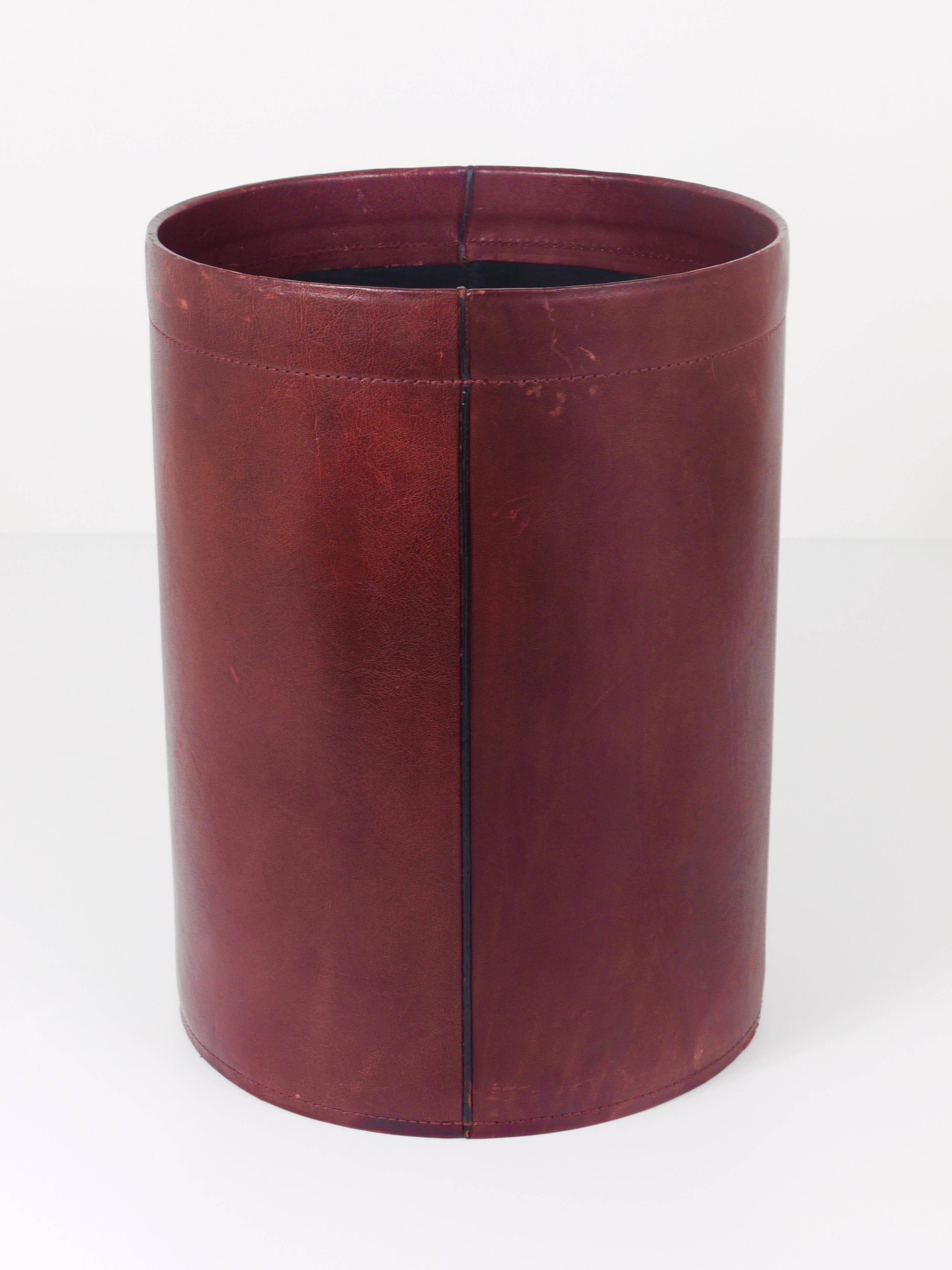 A beautiful and elegant, vintage Mid-Century Modern paper basket / paper bin from the 1970s. Handmade and hand-sewn from bordeaux red / brown leather, with a black leather interior. In good condition with nice patina on the leather. Diameter 10