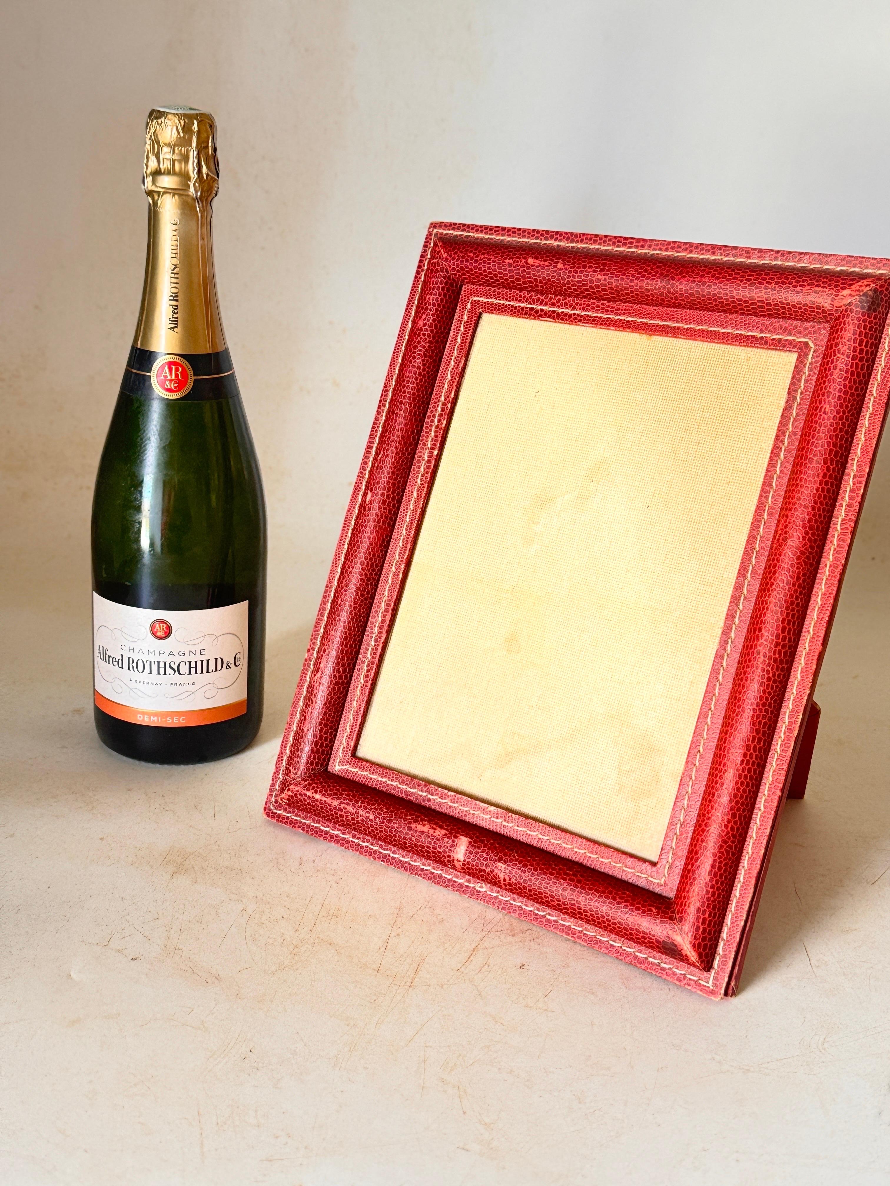 This Picture frame, is in stitched leather, in a light Red color. It is done in the style of Jacques Adnet. Some Wear but almost on the sides. It has been made in France circa 1940, it is the Art Deco Period.
