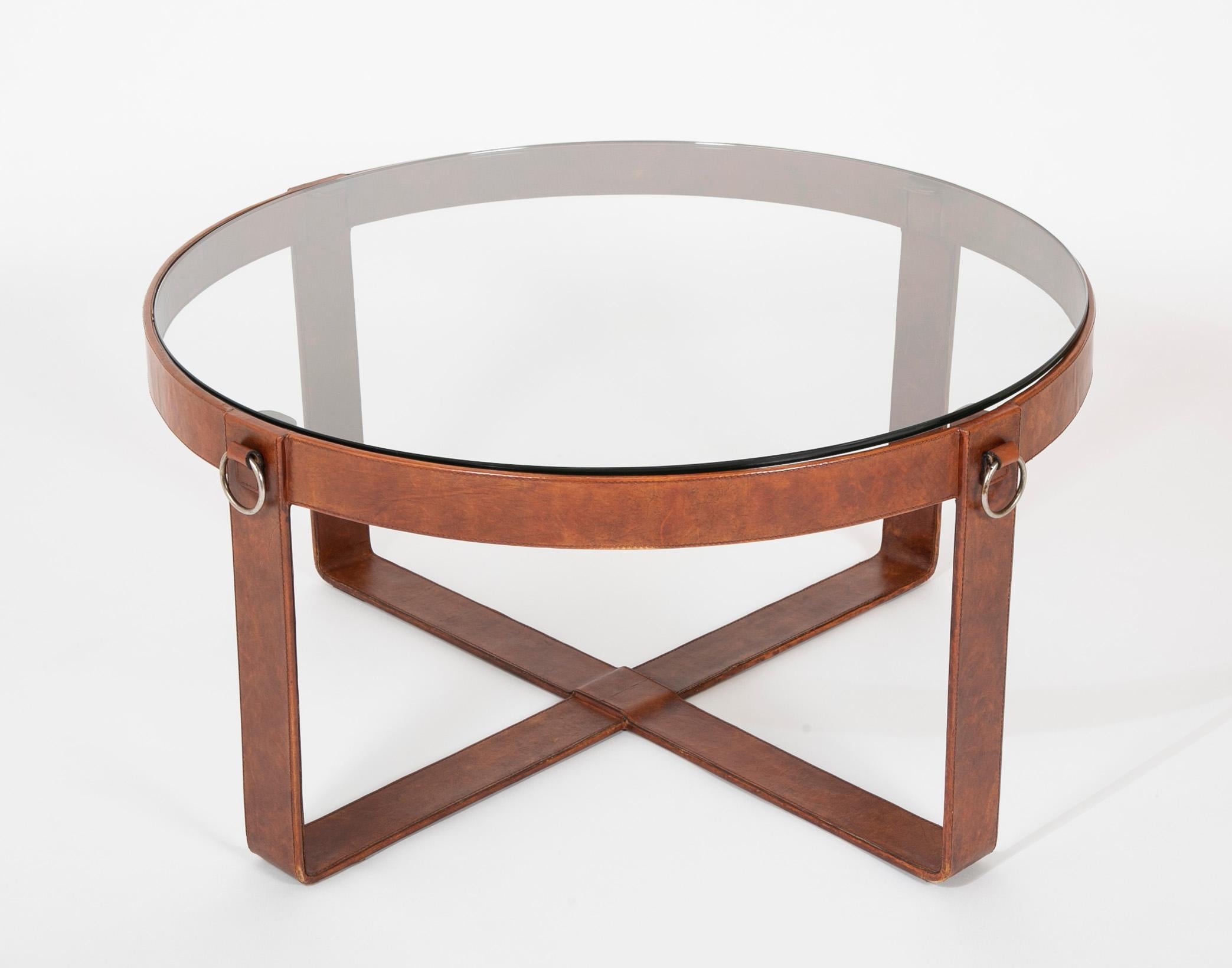 Mid 20th century French leather-wrapped iron round coffee, cocktail or side table with brass ring decoration, in the style of Jacques Adnet. With high quality craftsmanship, the leather stitching over the strap iron, this is a very handsome table.