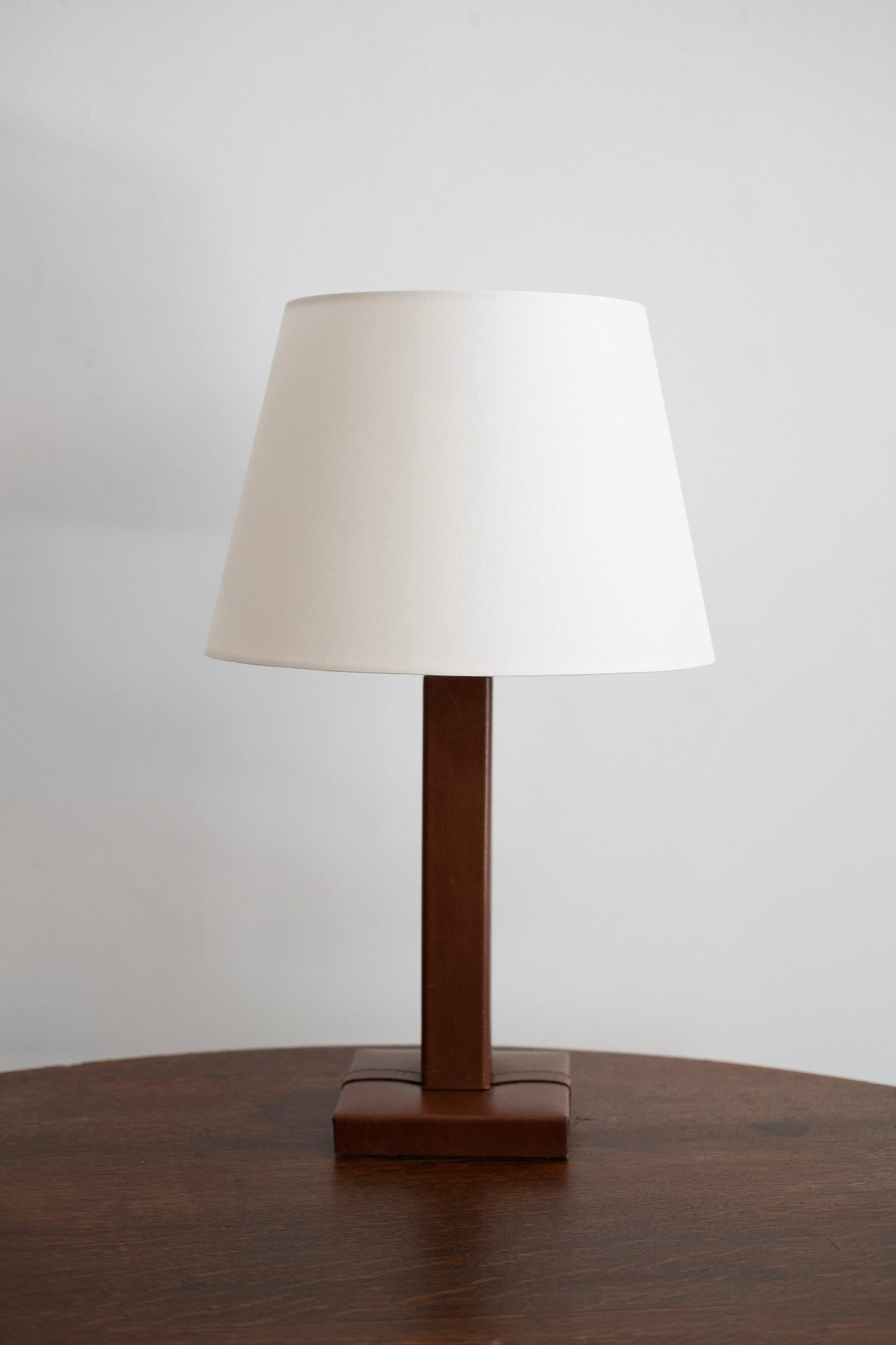 Jacques Adnet style table lamp. Aged brown leather with stitching. New shade and newly rewired.