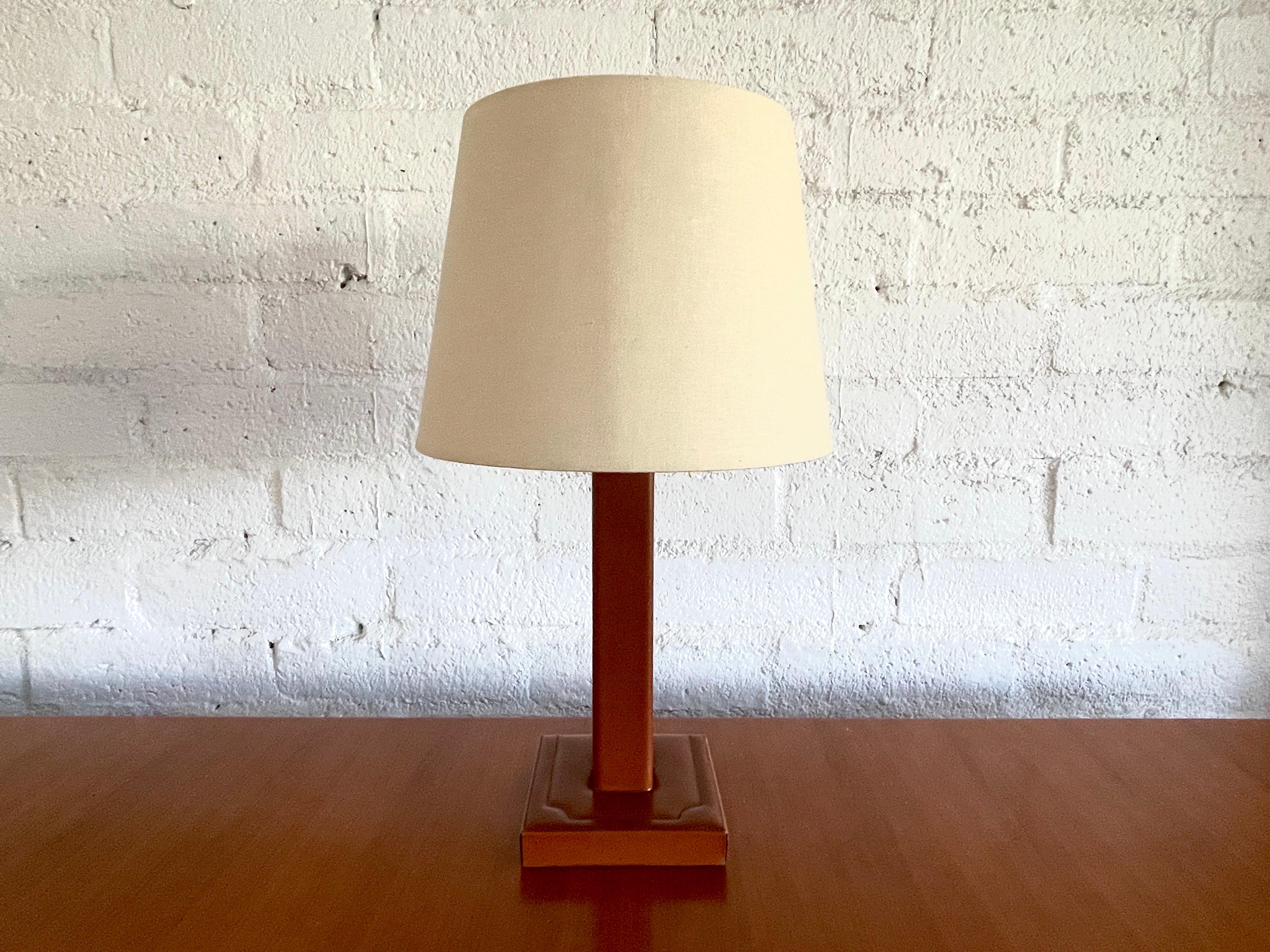 Jacques Adnet style table lamp in aged saddle brown leather with signature contrast stitching.
New silk shade and newly rewired.