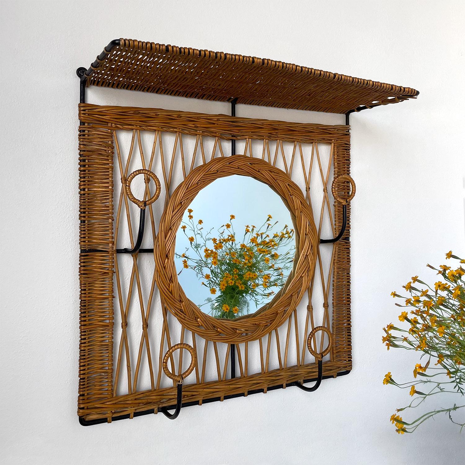 Jacques Adnet style wicker and iron mirrored coat rack
France, circa 1950s
Beautiful entry piece
Intricately woven willow delicately wraps iron frame
Longer willow reeds create a crisscross patterned backdrop
Braided willow framed mirror
Four
