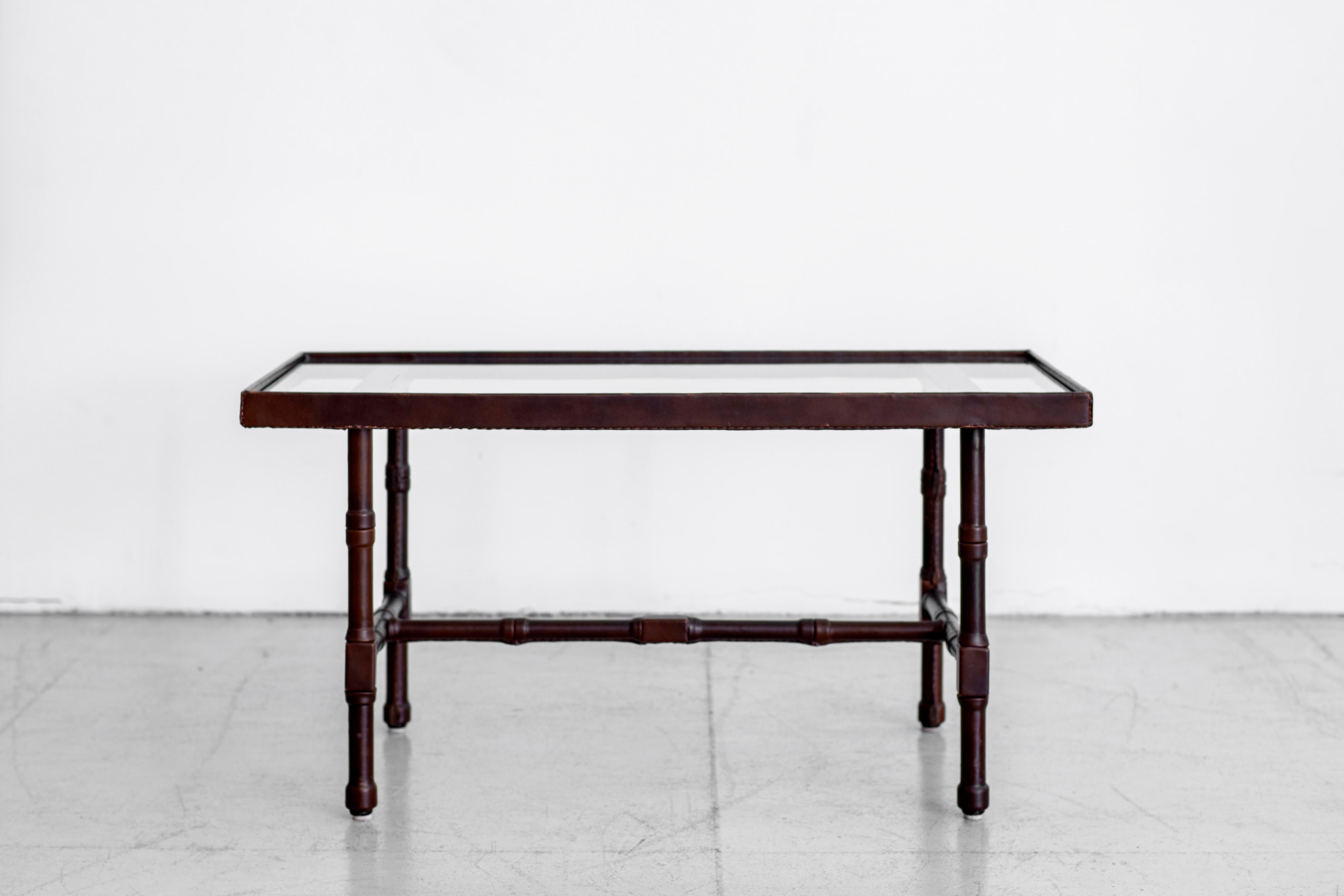 Fantastic skai leather low table with glass top by Jacques Adnet. 
Rich dark brown color leather with nice patina.