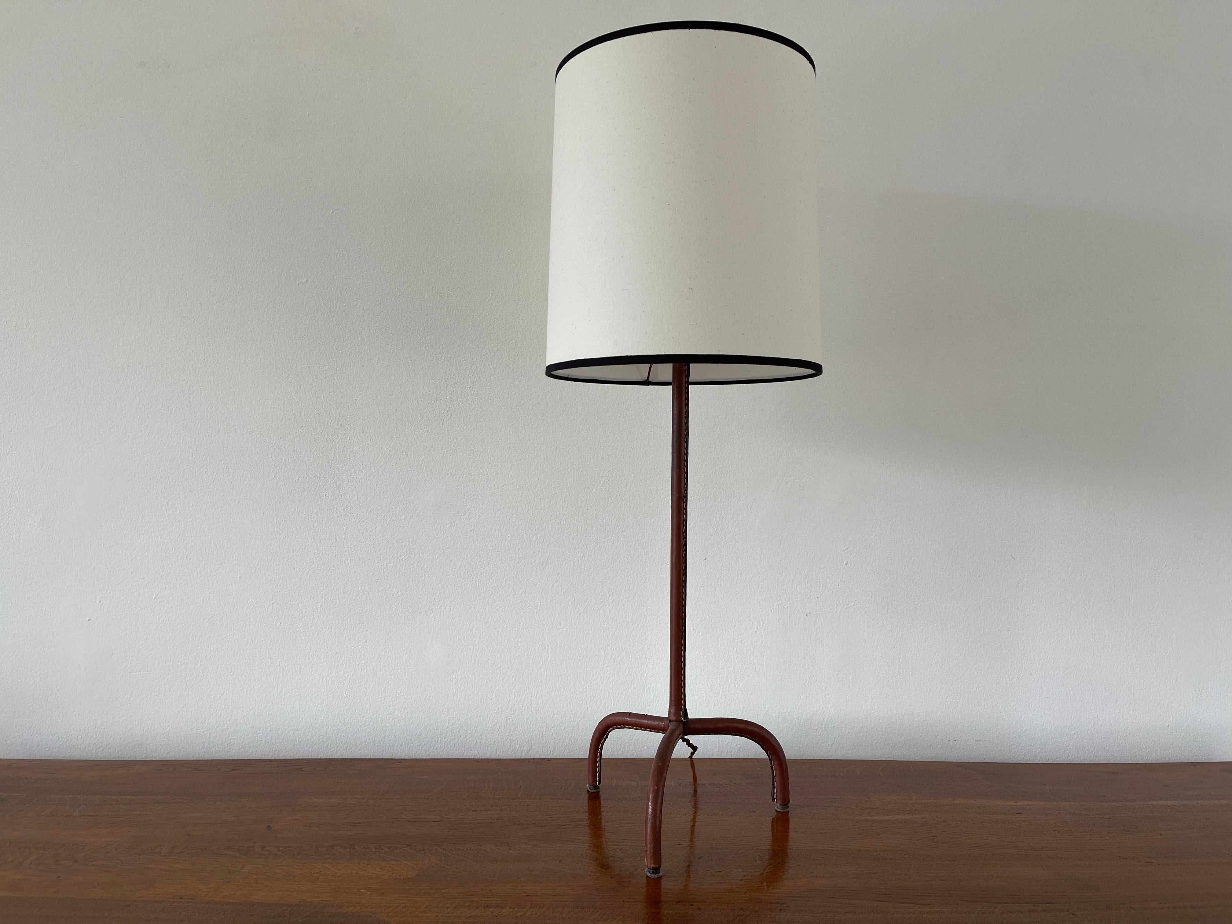 Jacques Adnet table lamp with caramel leather 
Contrast stitching with tripod base and new shade.