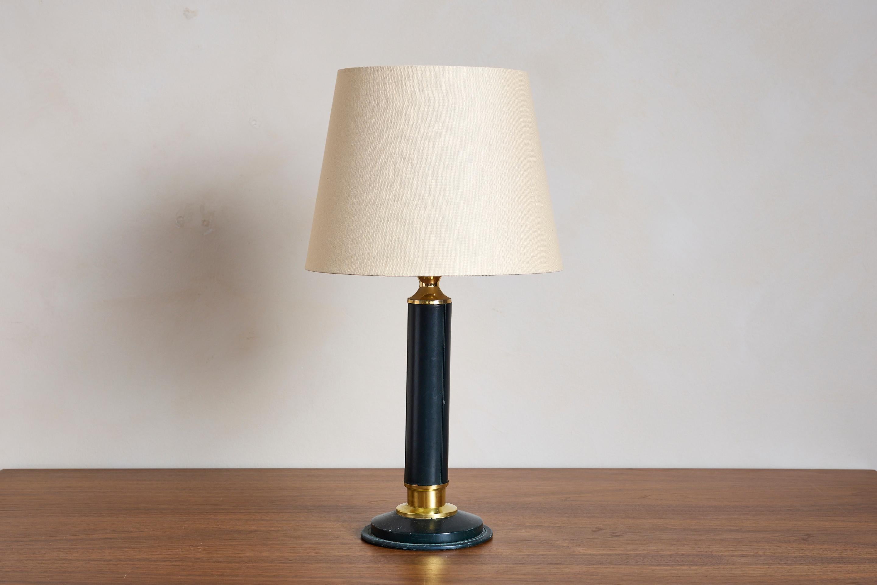 Jacques Adnet black leather table lamp with wonderful black leather with worn patina and brass details. 

New linen shade / Newly Rewired

France, 1950s