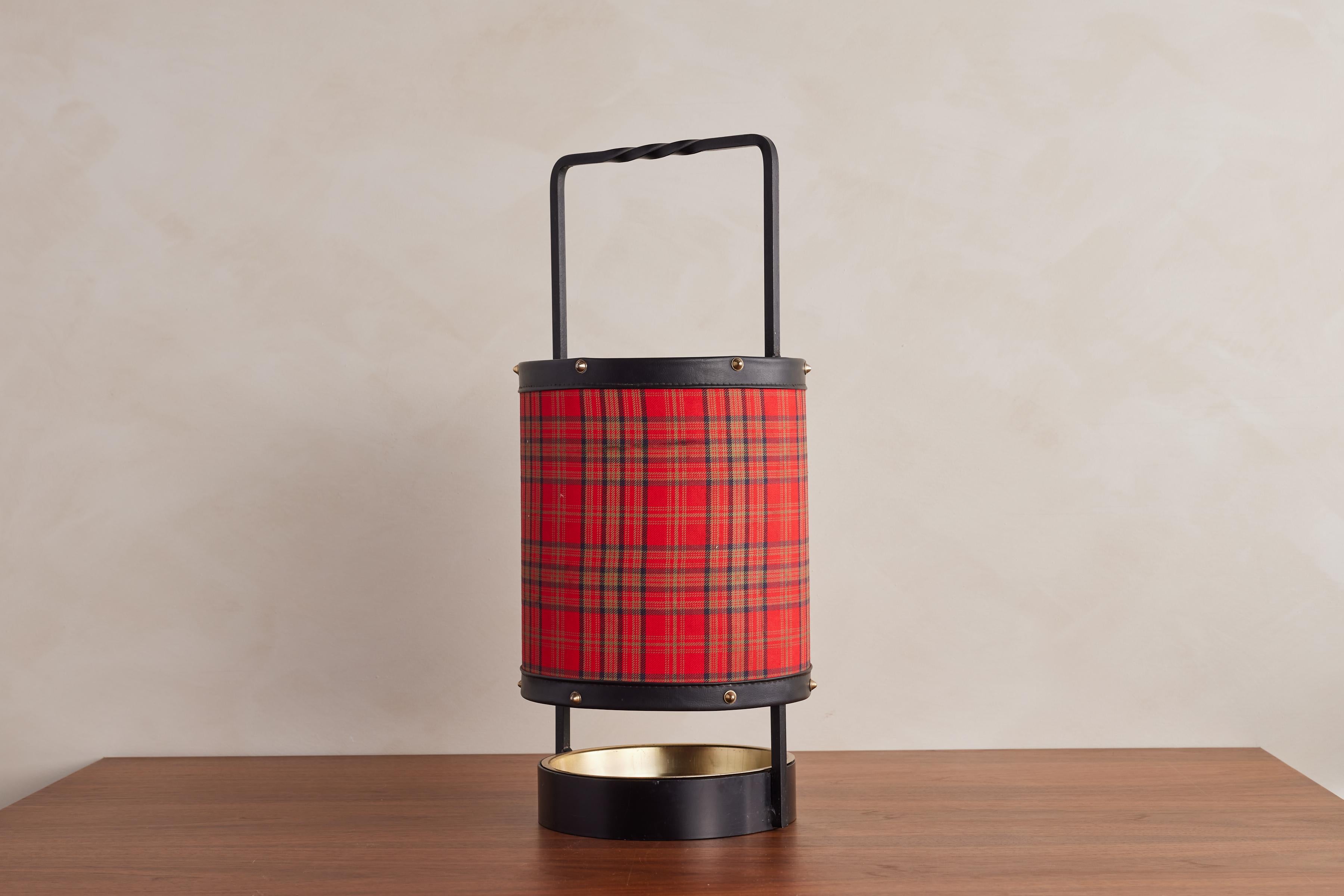 Handsome leather umbrella stand by Jacques Adnet.

Classic Tartan Fabric with signature Adnet contrast stitching and beautiful patina. 

Inset iron dish at the base to collect water. 

Excellent vintage condition. 