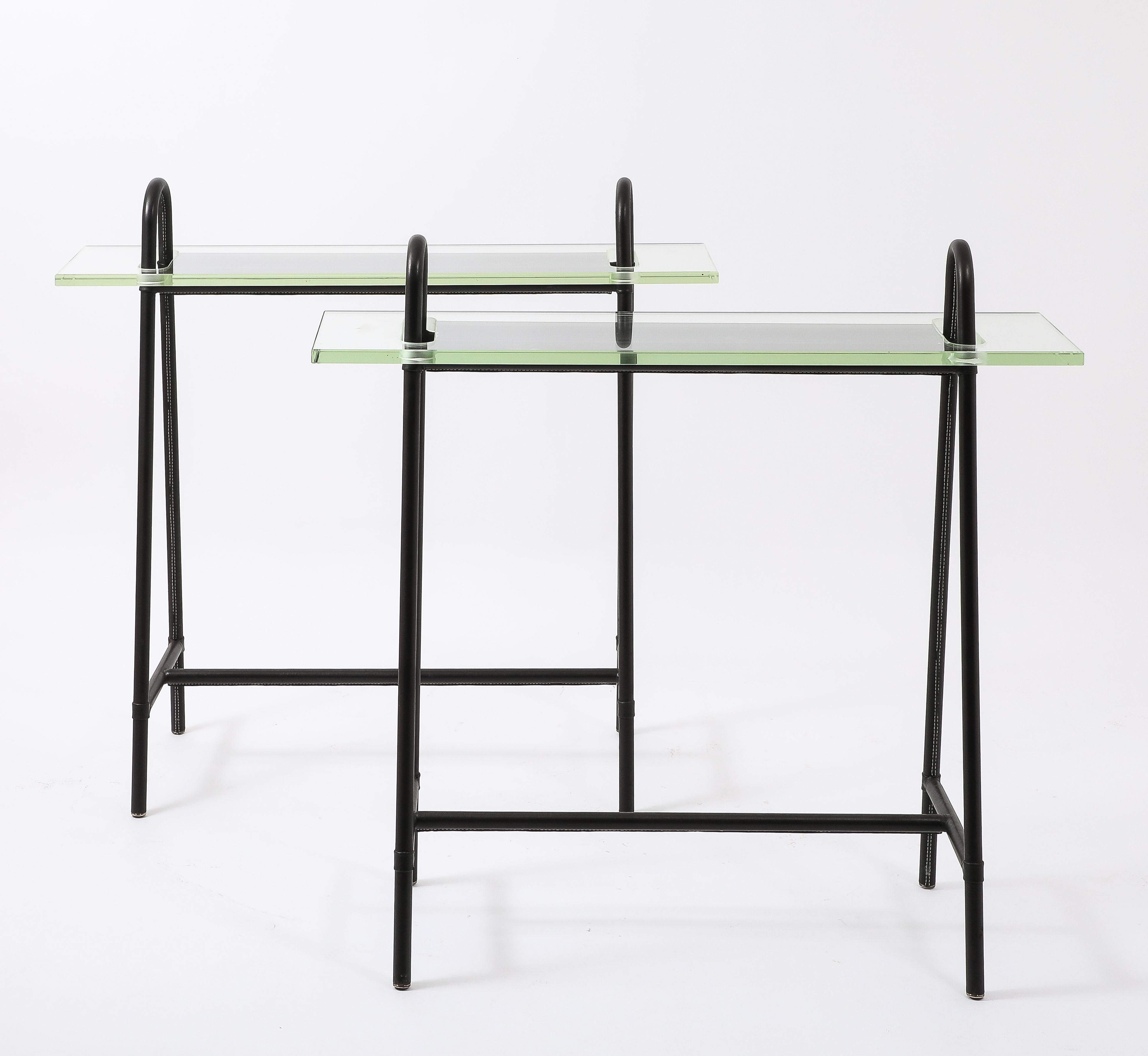 Consoles gainées de cuir avec plateaux en verre Saint Gobain et quincaillerie en laiton.