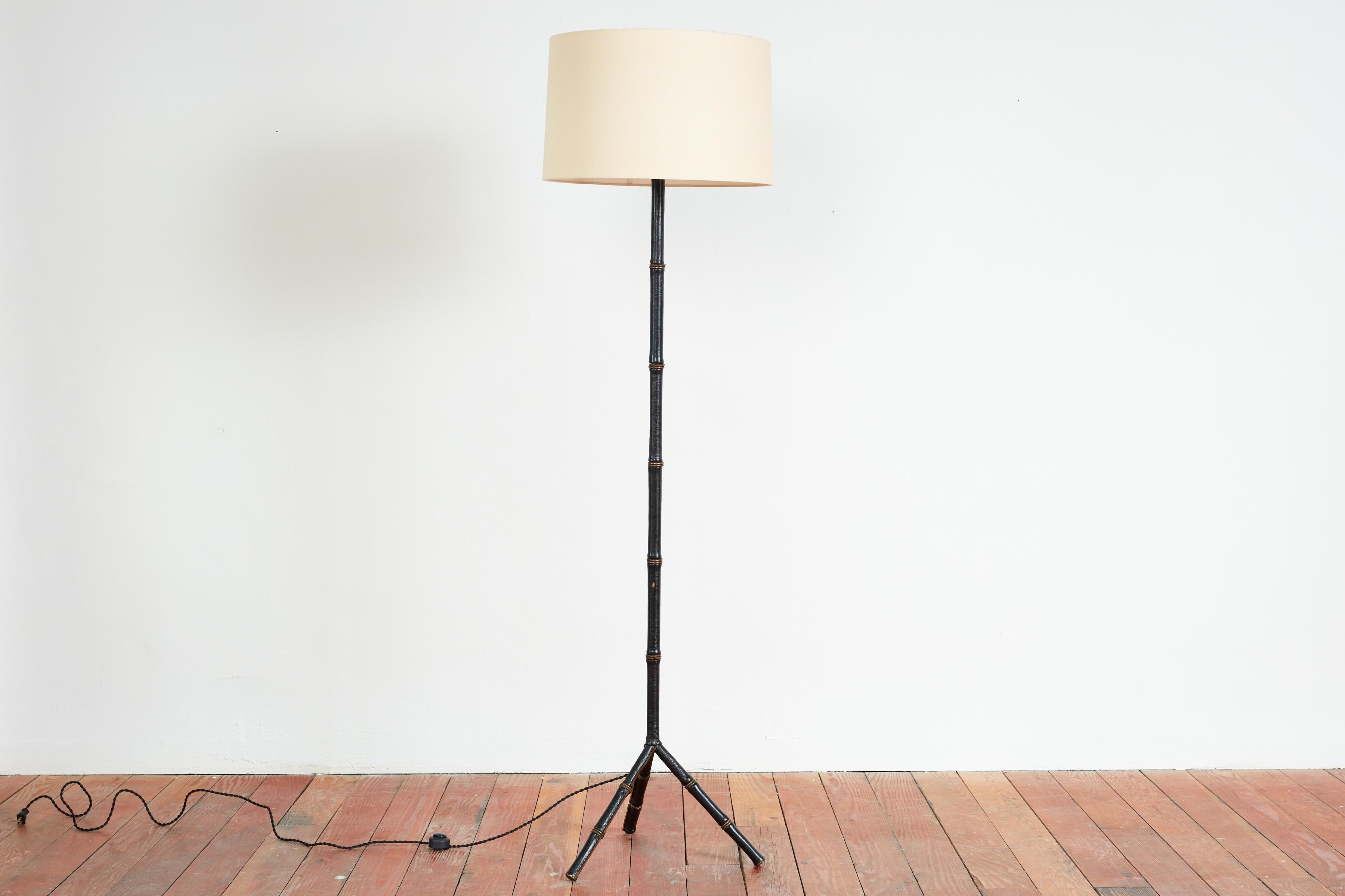 Jacques Adnet Floor Lamp with tripod base - France, 1940s
Signature leather bamboo stem 
New silk shade 
Tall and substantial in size and scale.